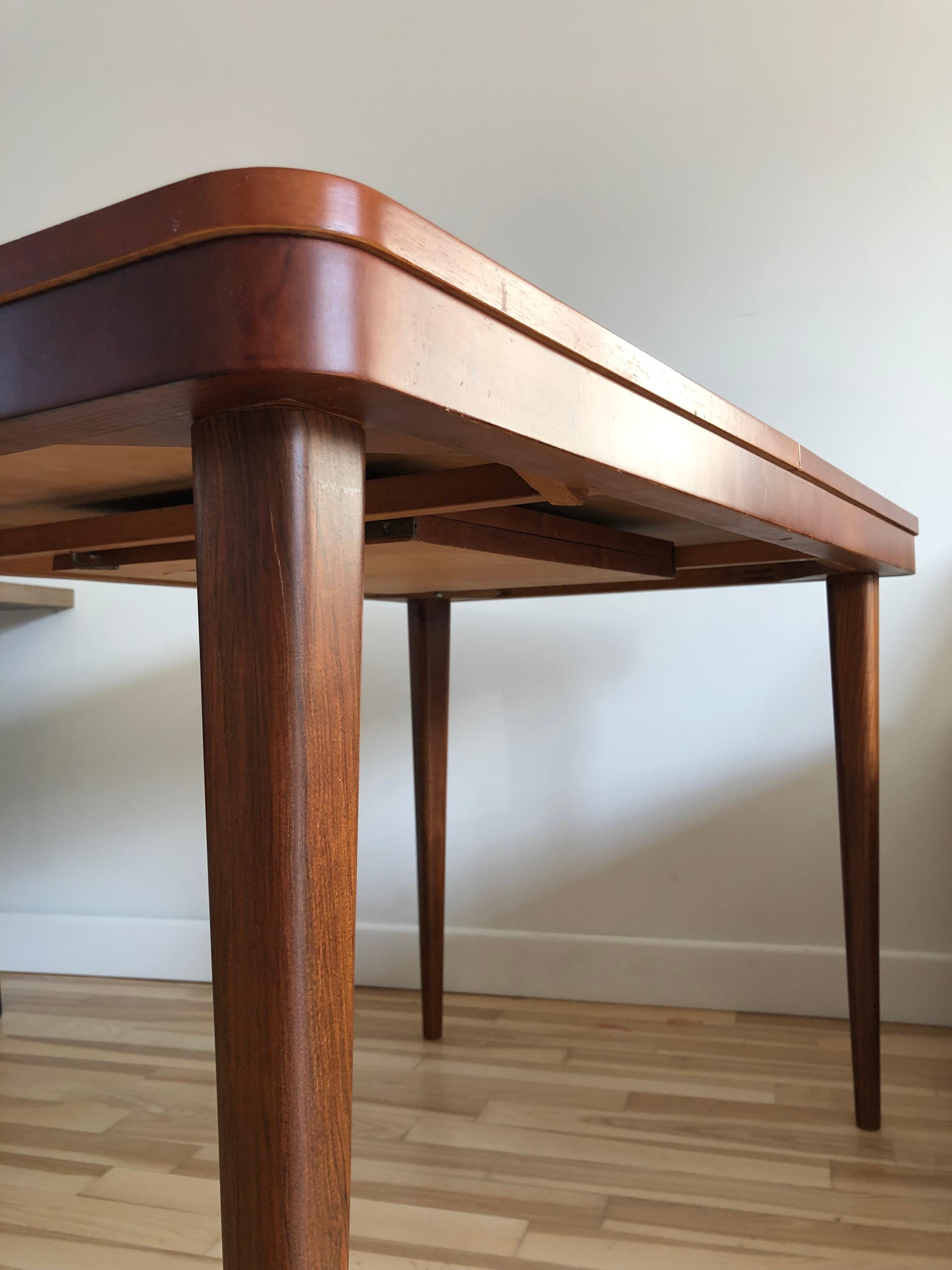 Très élégante table de salle à manger, conçue par le célèbre architecte tchèque Jindrich Halabala dans les années 1940, dans une chaude couleur de noyer, finie avec un vernis mat. La table est réglable de 120 à 170 cm. Il a été rénové