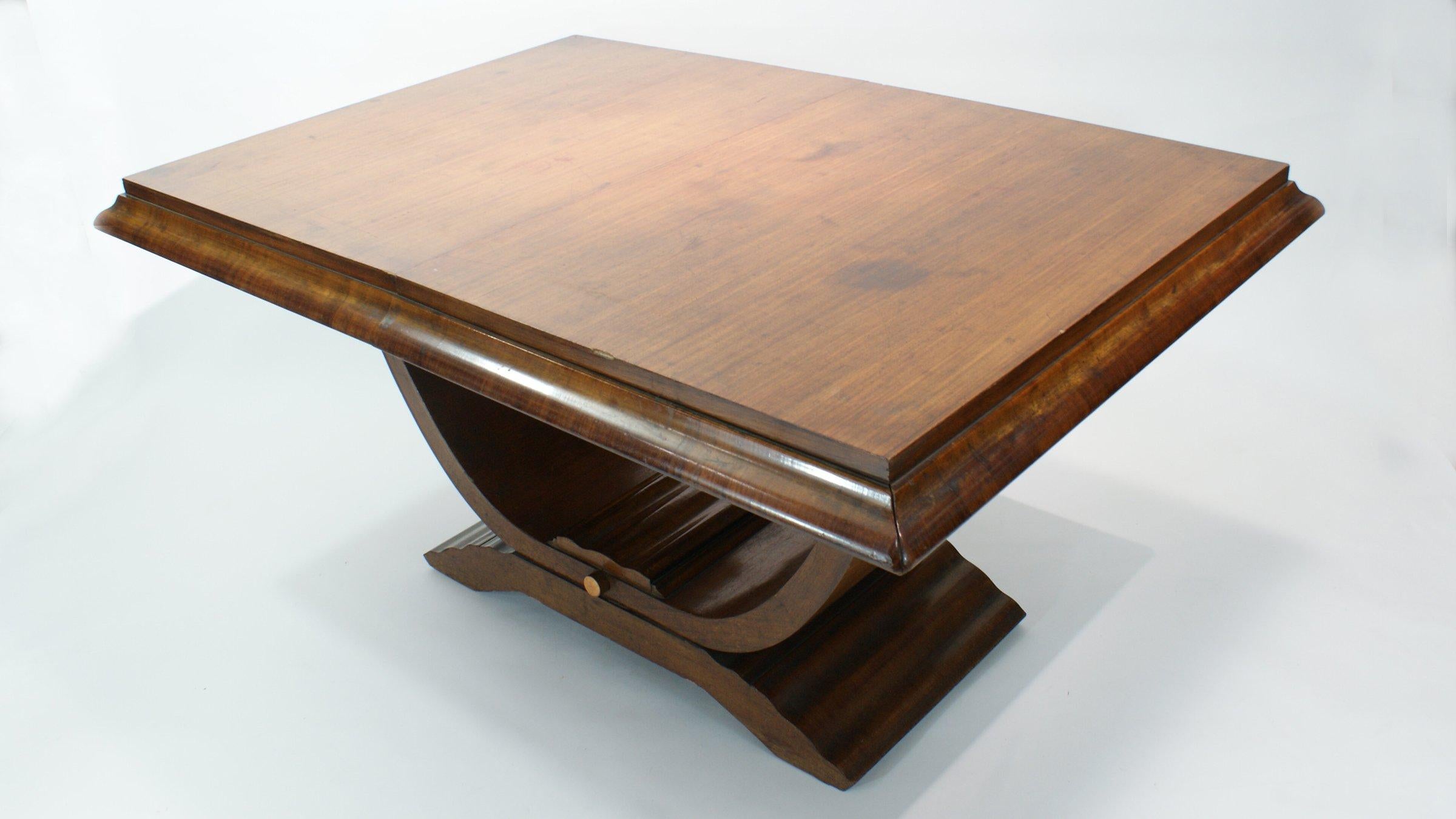 Art Deco small dining table in the manner of Ruhlmann with a stepped and molded top and overhang, raised on a curved platform base, with nickel detail and softly carved fluted detail, circa 1940.
 