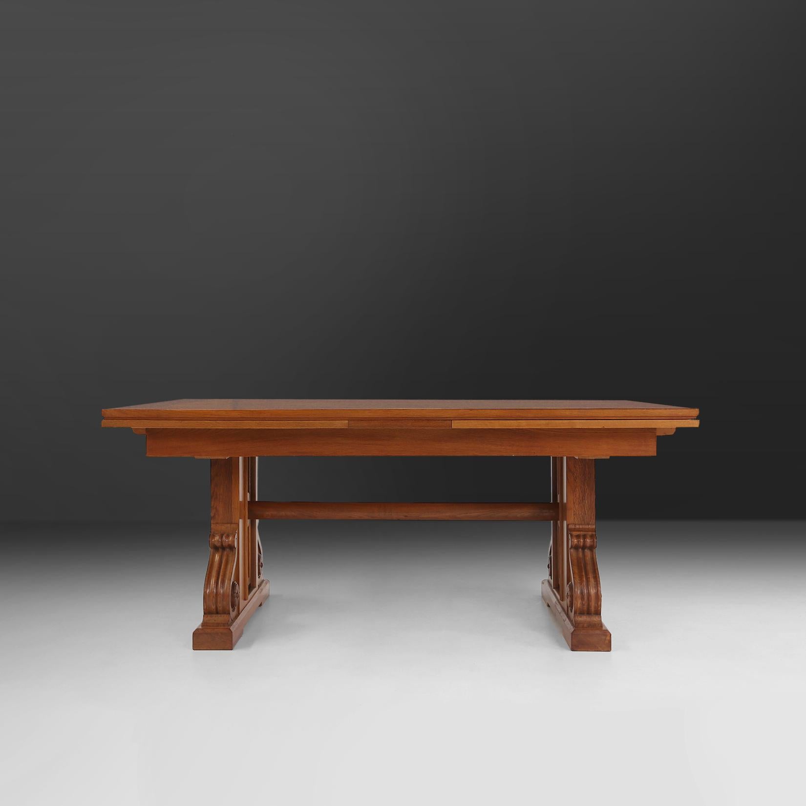 Belgian Art Deco dining table madeof solid oak wood.
Beautiful designed table with representing the Art Deco period of the 1940s. With a base consisting of large monumental legs with beautifully sculpted details. The two extendable leaves makes