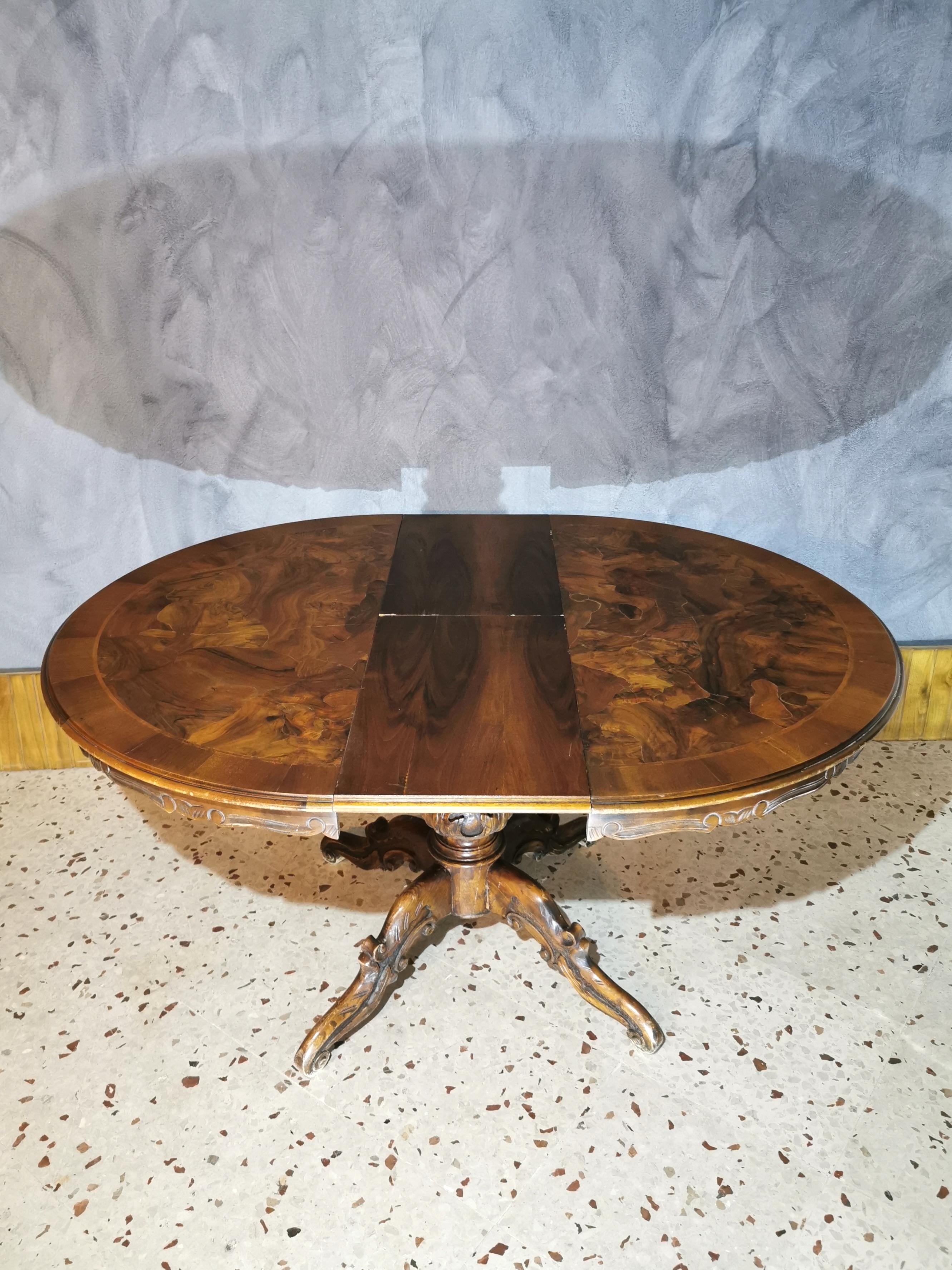 Round dining table Art Deco style, by Luigi Filippo in solid dark walnut wood with hand carvings and briar decoration, all on the top with 4 final curly feet, 1930s.