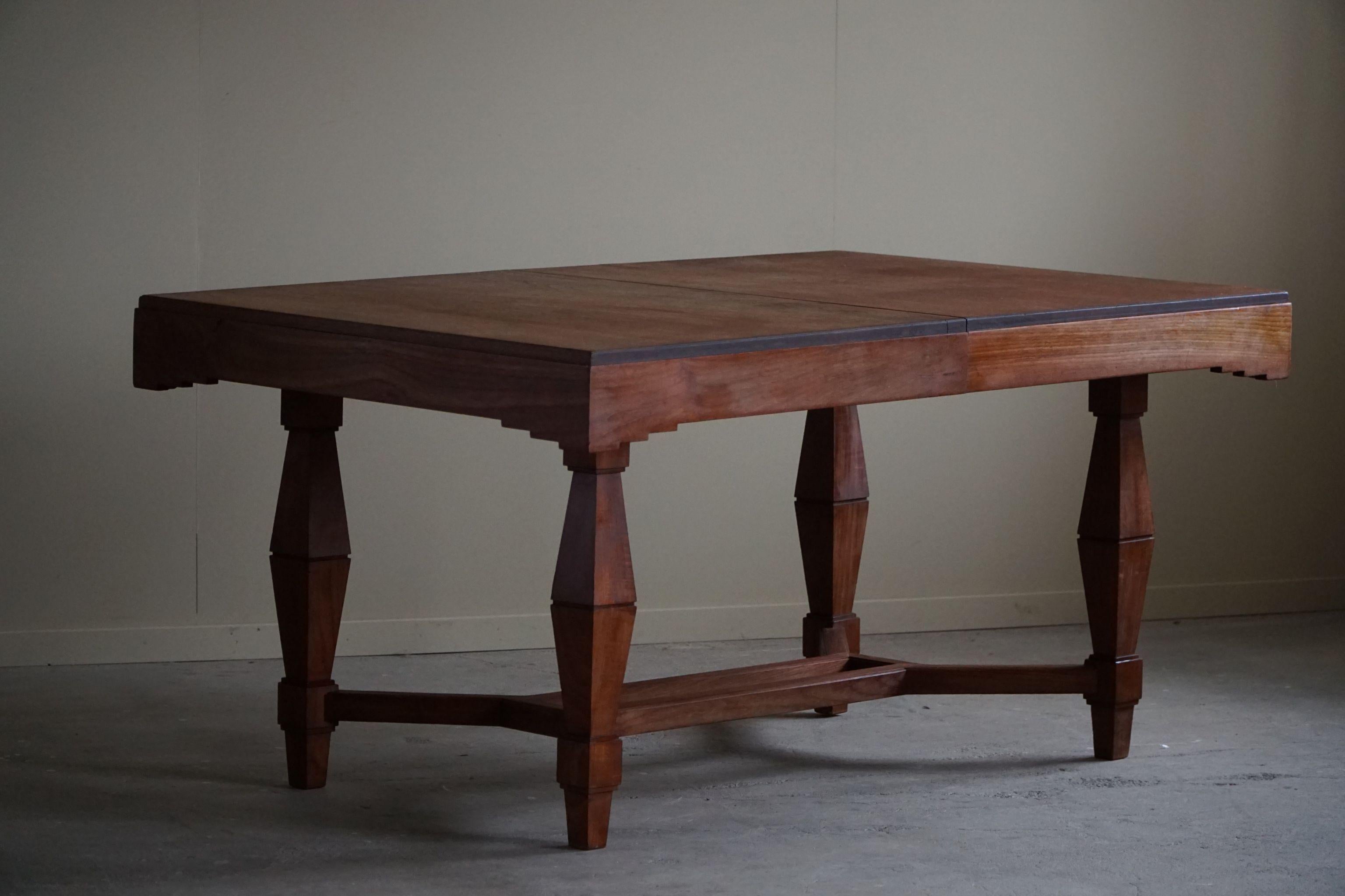 This Art Deco dining table from the 1940s, crafted by a Danish cabinetmaker, is a stunning fusion of style and functionality. Made from rich teak wood, it exudes warmth and elegance, while its Art Deco design elements add a touch of elegance. The