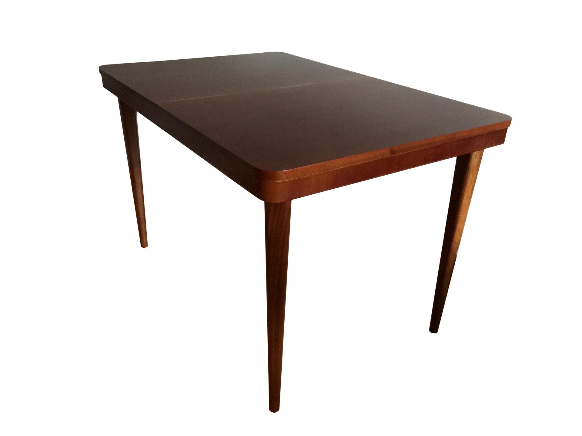 Very elegant dining table, designed by world famous Czech architect Jindrich Halabala in the 1940s, in warm walnut color, finished with a matte varnish. The table is adjustable from 120 to 170 cm. It has been professionally renovated by a specialist