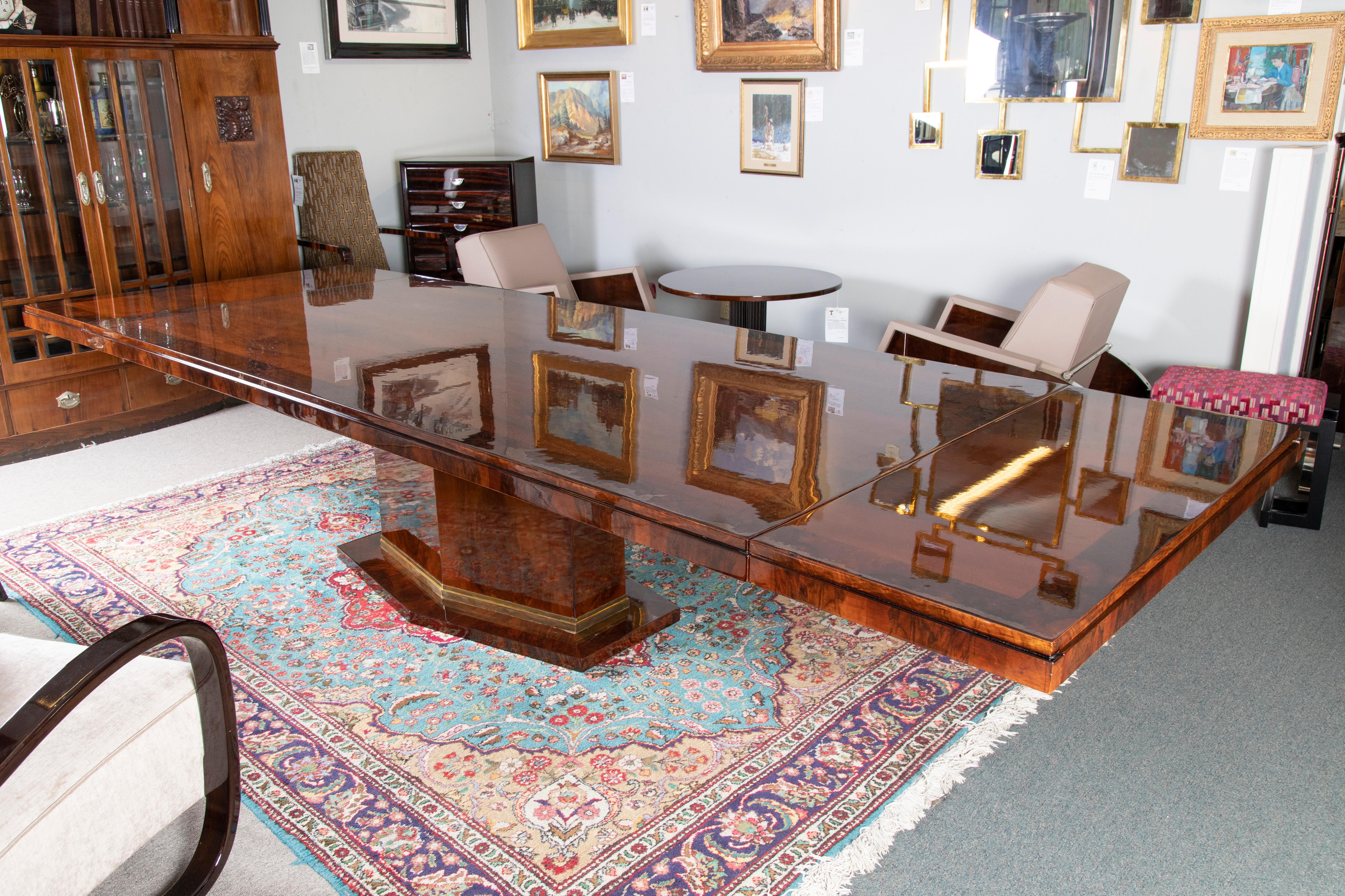 Rectangular table top is displaying beautiful walnut wood with ebonized edges. Table top is resting on hexagon shaped base. Base is embellished with brass decorative ribbon. 
There are 2 extensions on either side, 20 “ each. 


 France, c.