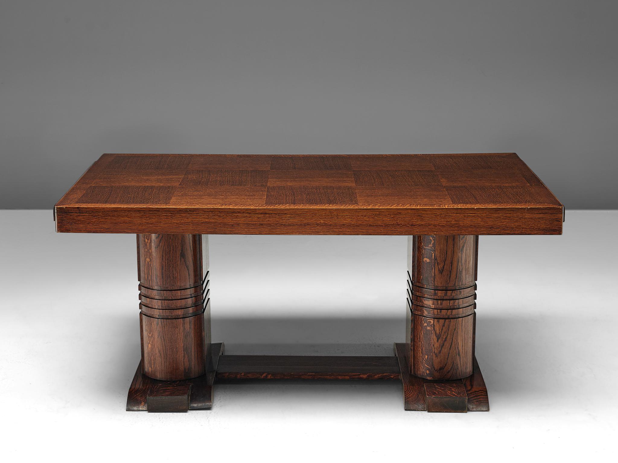 Dining table, oak, France, 1940s.

This well-designed dining table is architectural in its structure and alludes to the stylistics traits of the artistic Art Deco movement of the 1940s. The top has a checkered pattern that is created by alternately