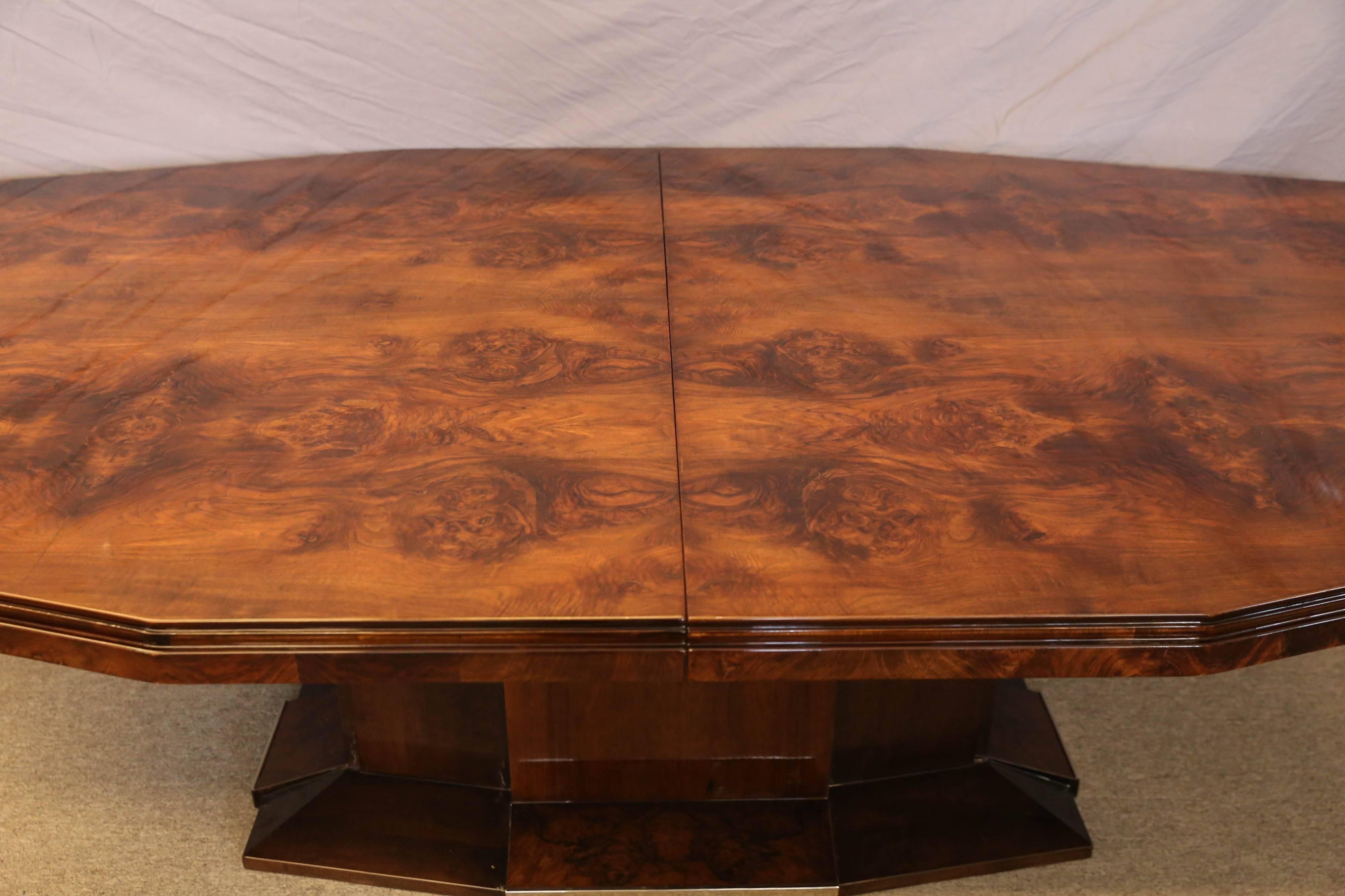 Dining room table is made out of burl walnut. The tabletop is displaying a beauty of the wood. It supported by the wide leg, that is embellished with chrome inserts on the bottom. The table has an extra 20” insert, which could be placed in the