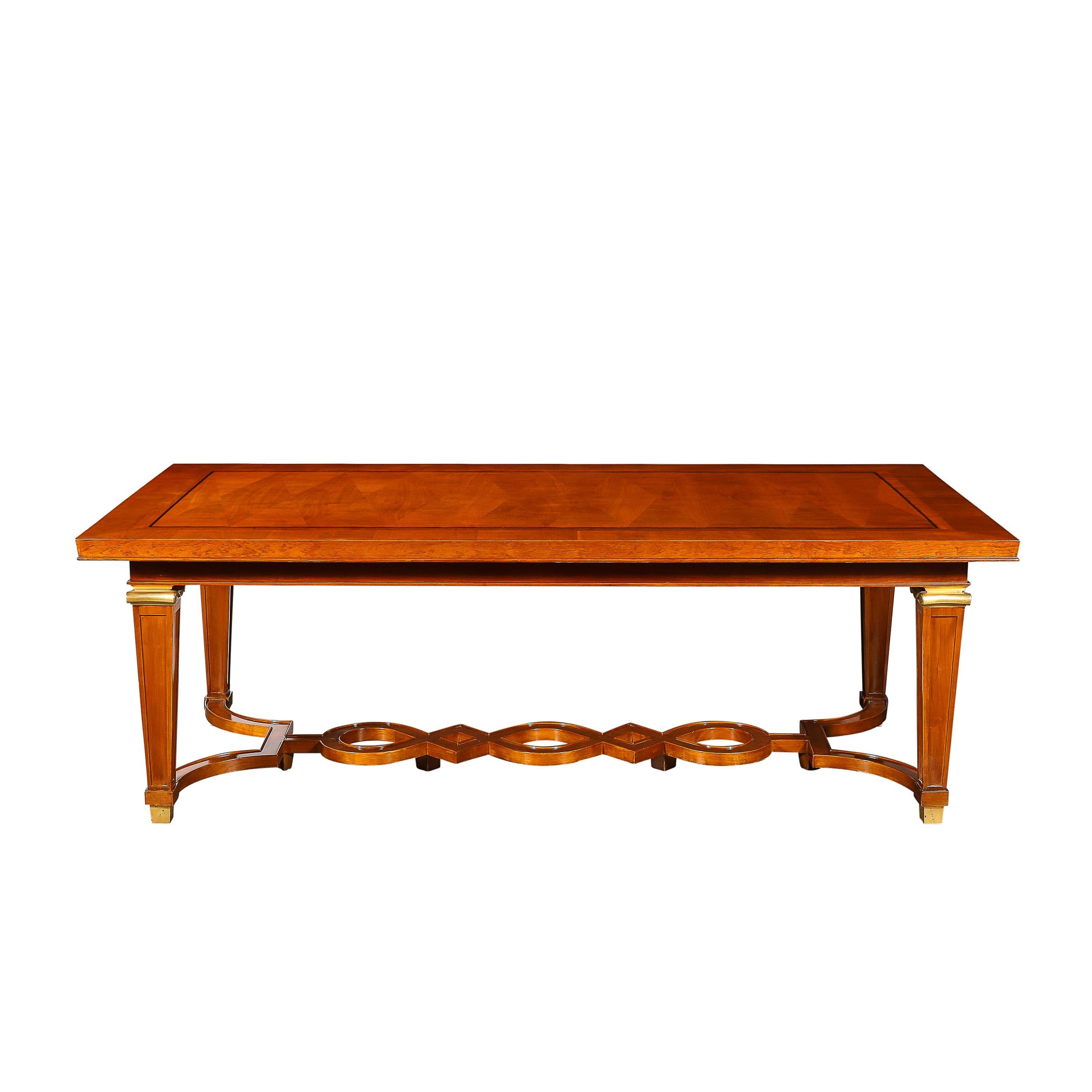 This breathtaking Art Deco Directoire Style Dining Table in Book-Matched Walnut W/Bronze Mounts & Ebony Inlay from L' Art De Vivre originates from France, Circa 1940. This stunning dining table features incredibly precise material execution and