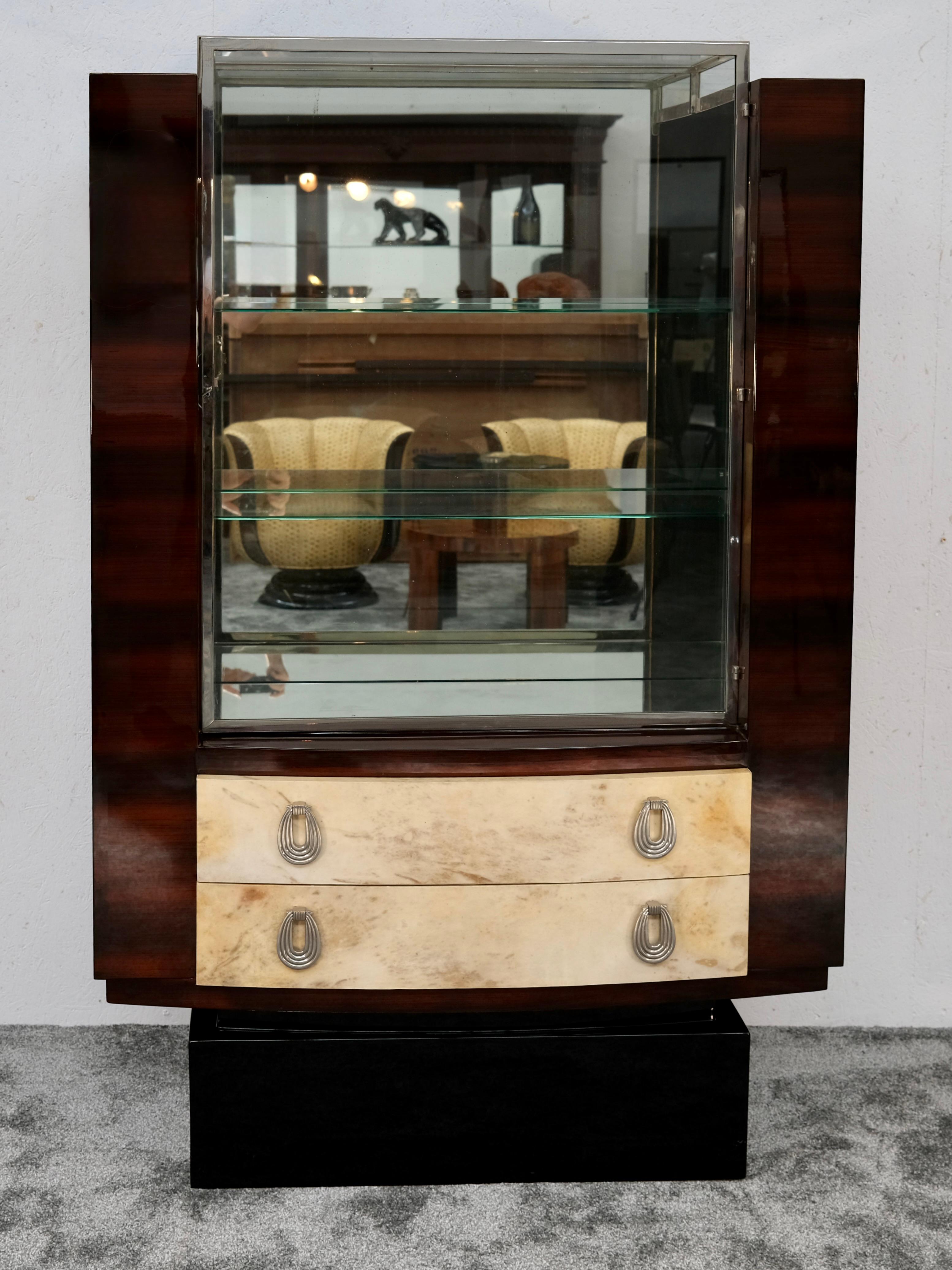 Esta excepcional vitrina Art Déco, firmada por el célebre ébéniste francés Christian Krass (Lyon), ejemplifica la elegancia y la artesanía del diseño de mobiliario francés en torno a 1930. Una sofisticada interacción de materiales caracteriza esta