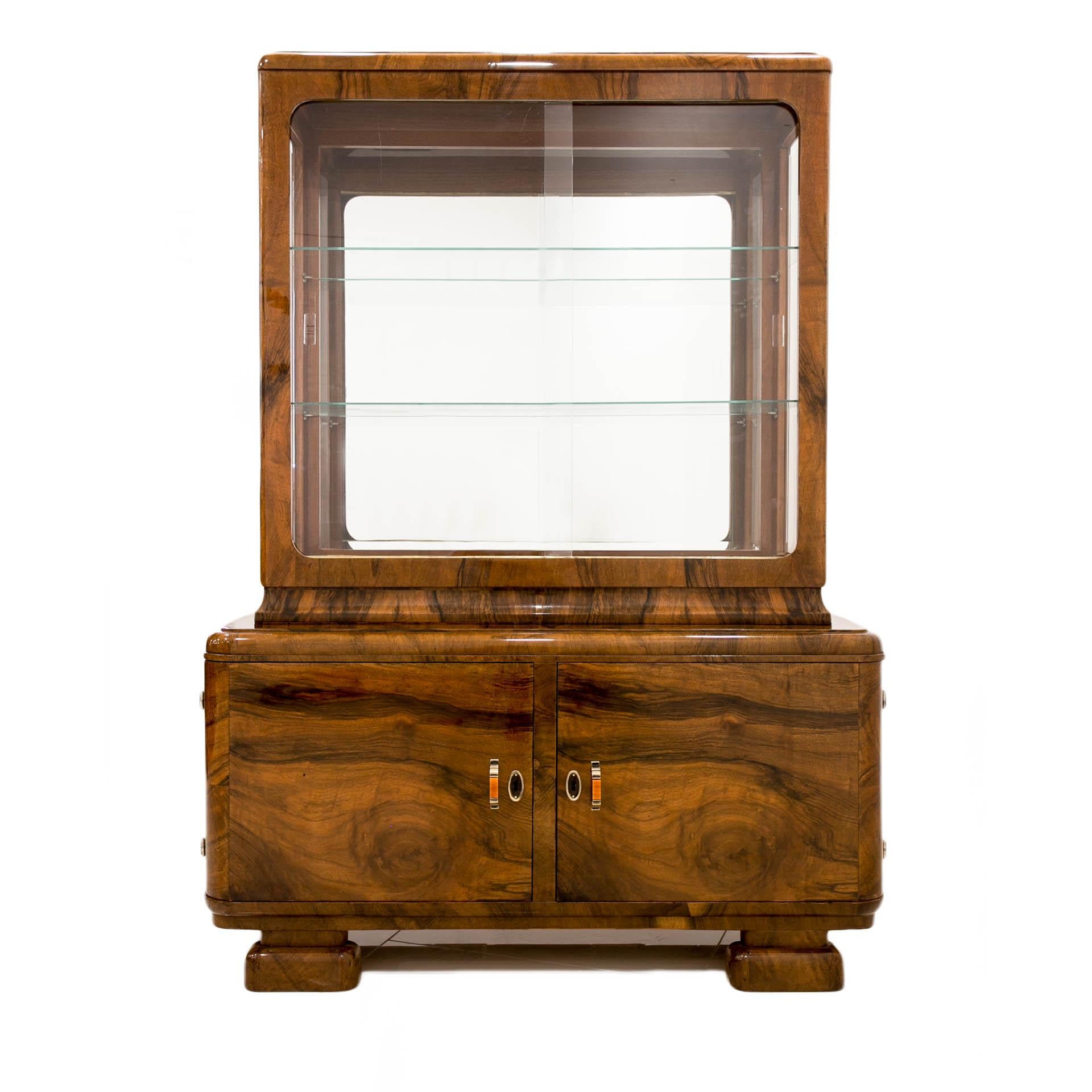 This beautiful Art Deco display cabinet comes from Poland and was made circa first half of 20th century. The structure is made of coniferous wood, veneered with beautiful walnut veneer. The piece is after professional renovation and is in excellent
