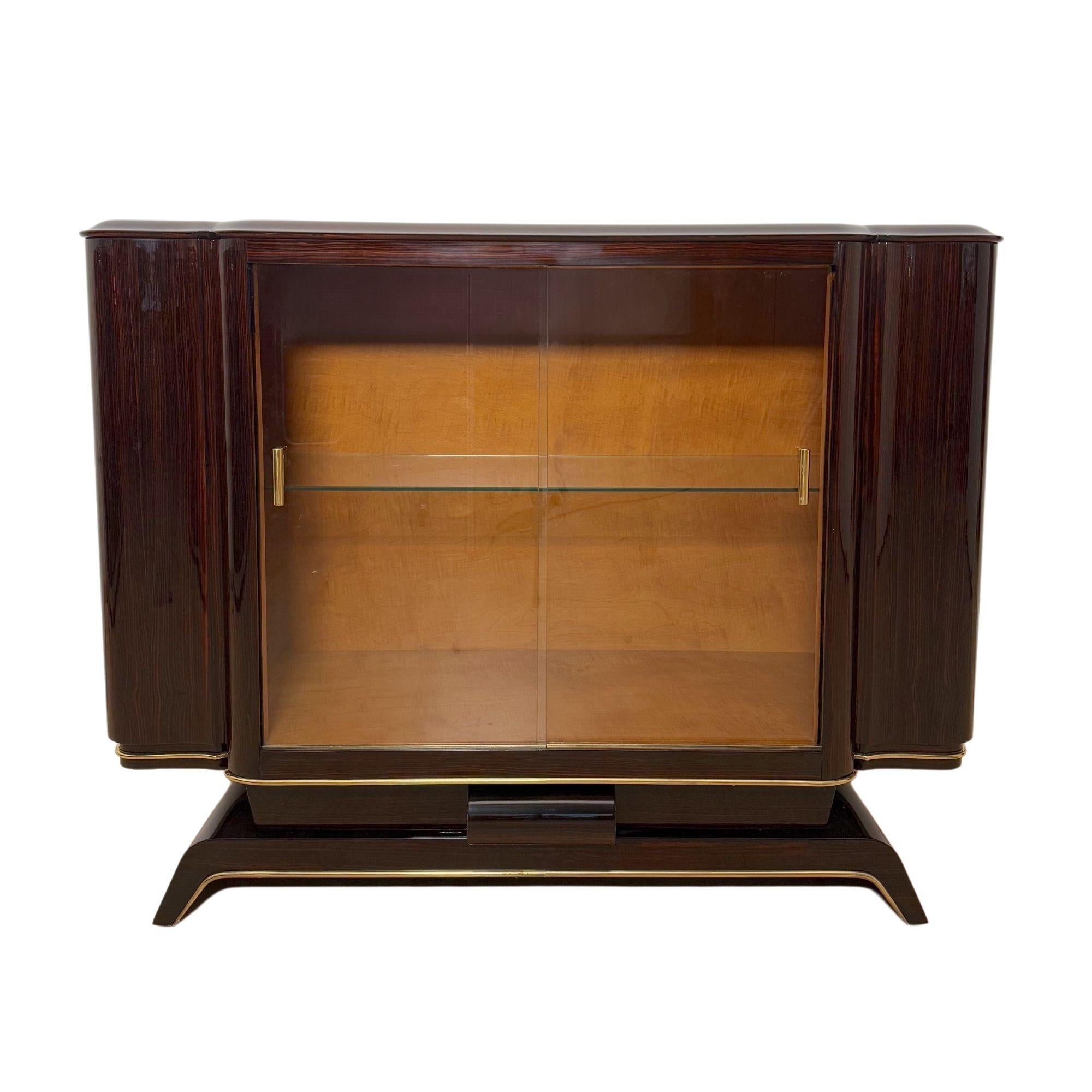 Großartig restaurierte Vitrine aus Makassar-Ebenholz, verglaste Anrichte oder Buffet aus Paris um 1930.
Makassar-Ebenholz furniert, lackiert und hochglanzpoliert. Original Messingbeschläge. Innenausstattung aus hellem Ahornfurnier mit Glasboden und