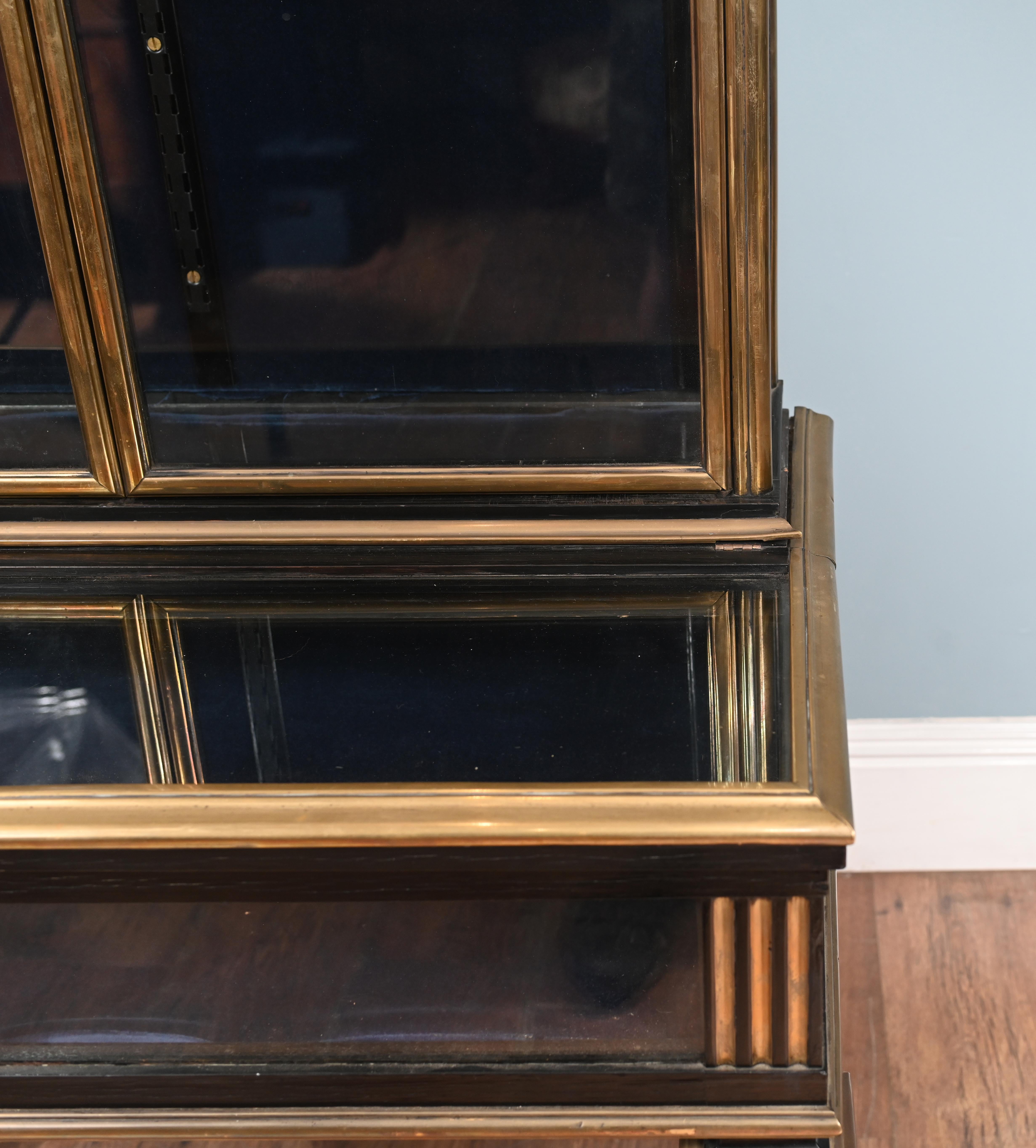 Vous regardez une élégante vitrine art déco avec une finition laquée.
La laque noire est rehaussée d'une garniture dorée qui lui confère un aspect 