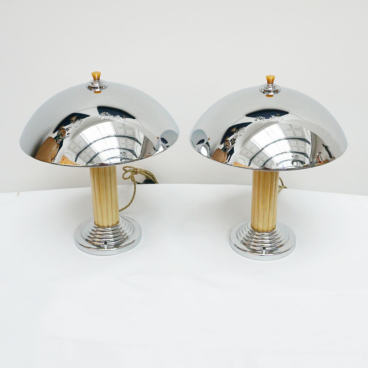 A Pair of Art Deco style dome lamps. Reeded yellow bakelite stem over a stepped chromed metal base. Yellow finial topped chromed metal shade. 

Dimensions: H 44cm Diameter of shade: 35cm, of base: 16cm

Item Number: J237

All of our lighting