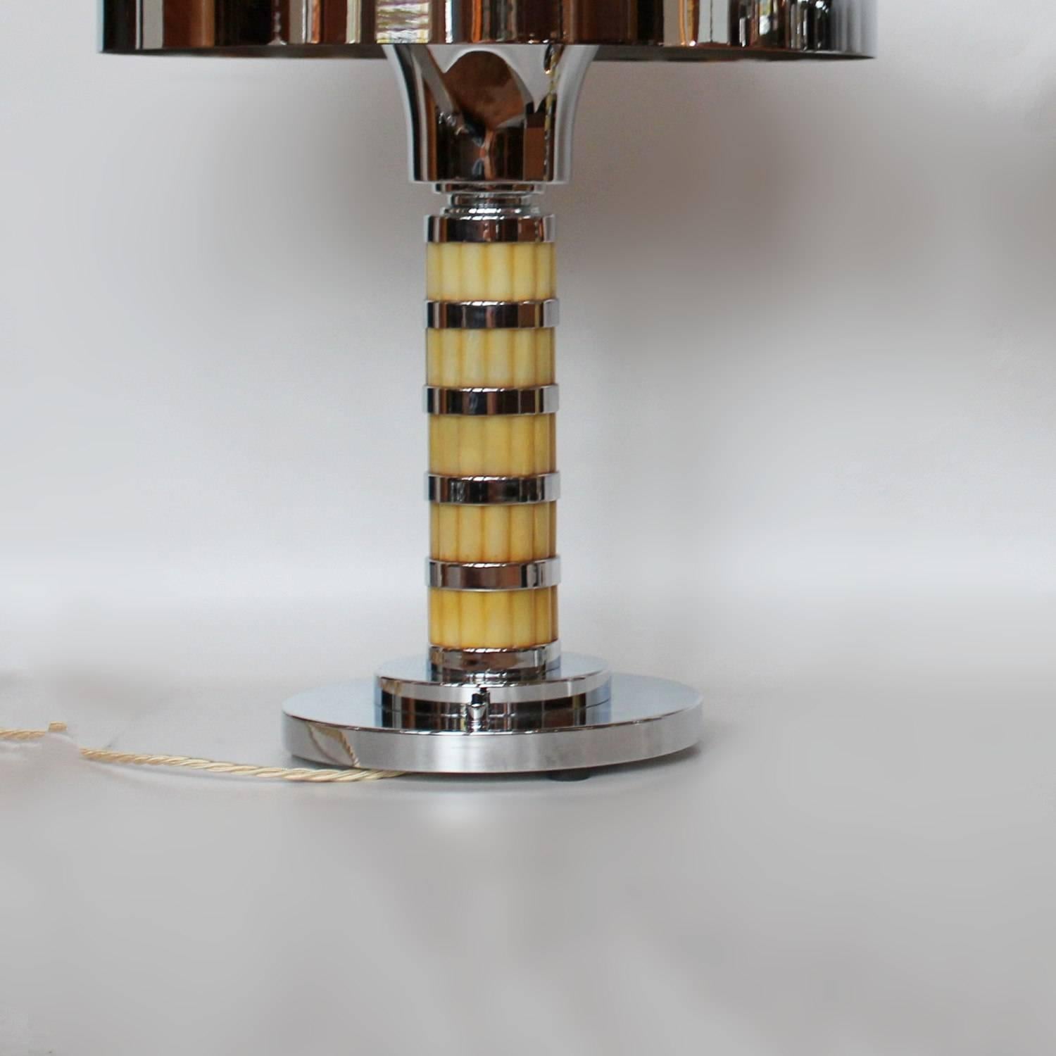 A pair of Art Deco table lamps with domed shades. Five sectioned reeded pale yellow bakelite stem with chrome metal banding. Chromed metal base. Yellow bakelite finial to top

Fully refurbished, re-chromed and re-wired

Dimensions: H 50 cm, W of