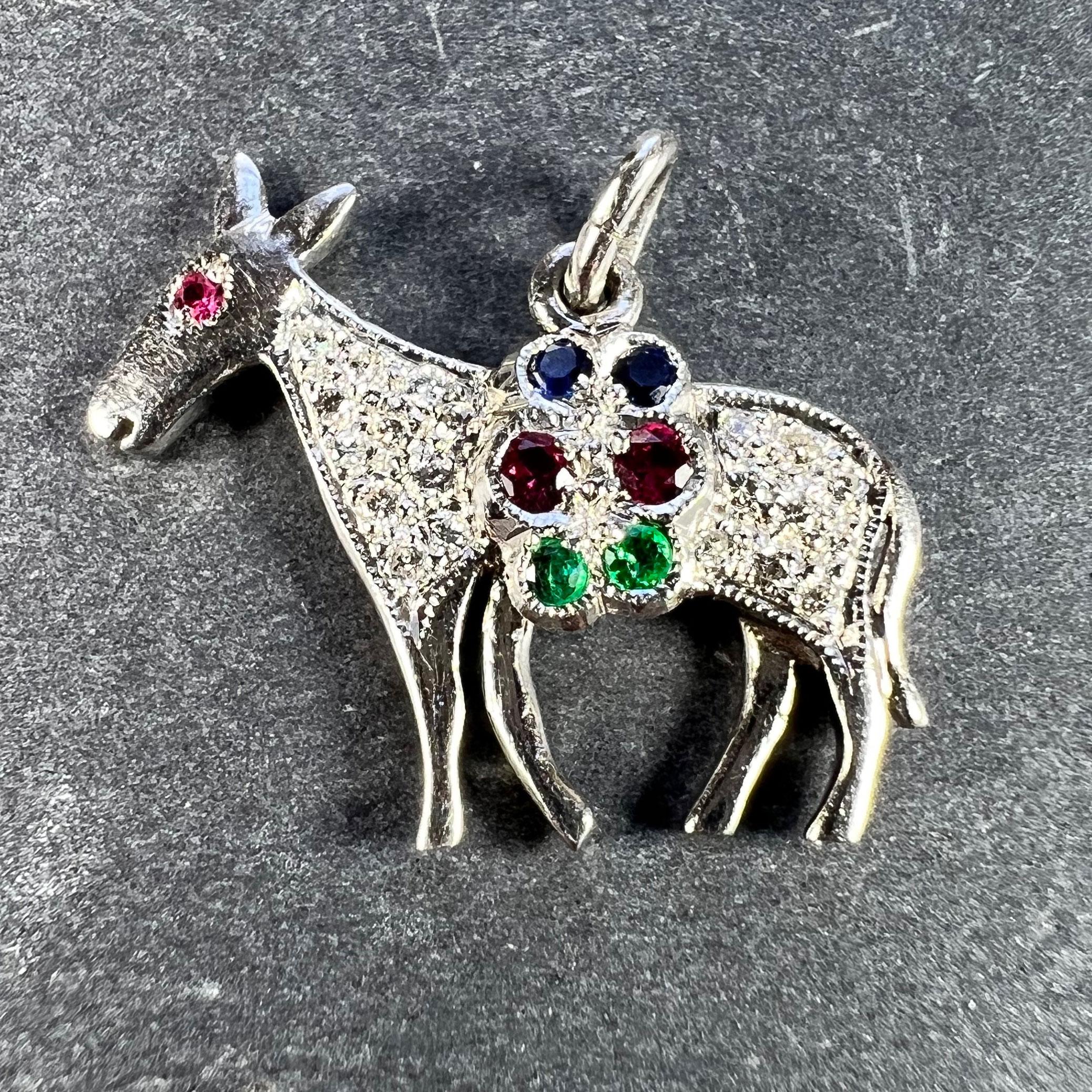 An Art Deco platinum charm pendant designed as a donkey, mule or horse carrying a pannier of gems, set with 20 round brilliant cut white diamonds, three rubies, two sapphires and two emeralds. Unmarked but tested for platinum.

Gemstone