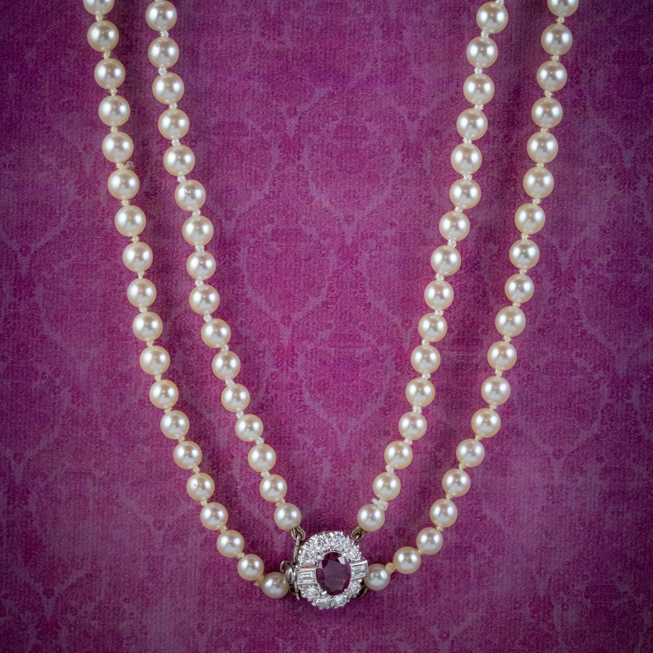 A grand Art Deco Pearl Necklace featuring two strands of lovely lustrous Cultured Pearls which graduate in size towards the bottom.

The piece is held together by a stunning 18ct White Gold box clasp converted from a ring face. It’s decorated with