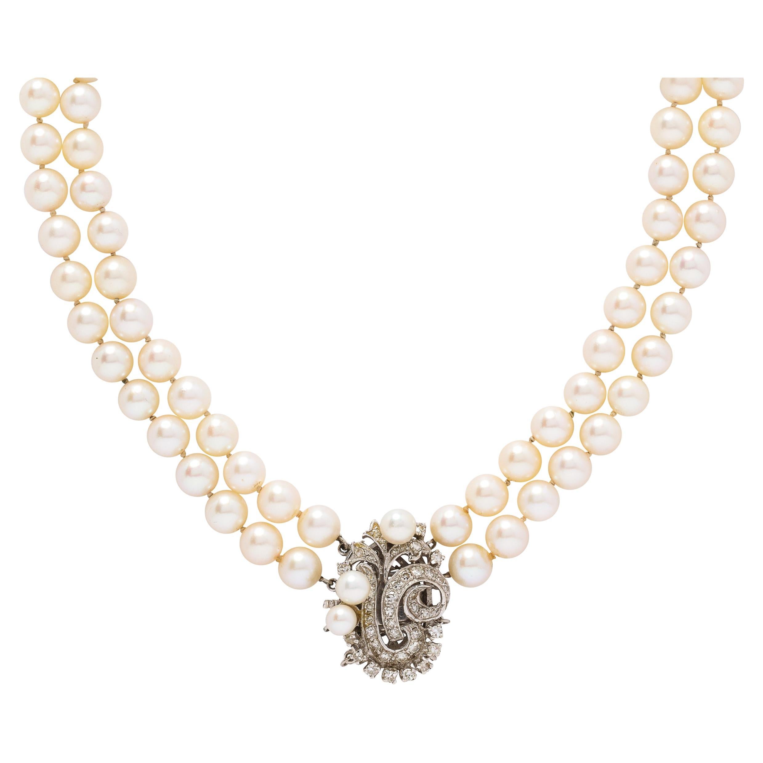 Art Deco double strand pearl necklace with a gold, diamond and pearl clasp. Individually knotted pearls measuring 7.5 mm each. With a 14k white gold clasp inlaid throughout with diamonds and accented further with 3 smaller pearls.Marked 14k. 13