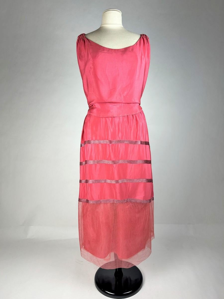 Circa 1920-1925
France
Briny coral pink silk crepe afternoon dress, probably Haute Couture and dating from the 1920s. Sleeveless dress with round neckline and very elaborate construction. Openwork blousant top with smocked straps. Back panel