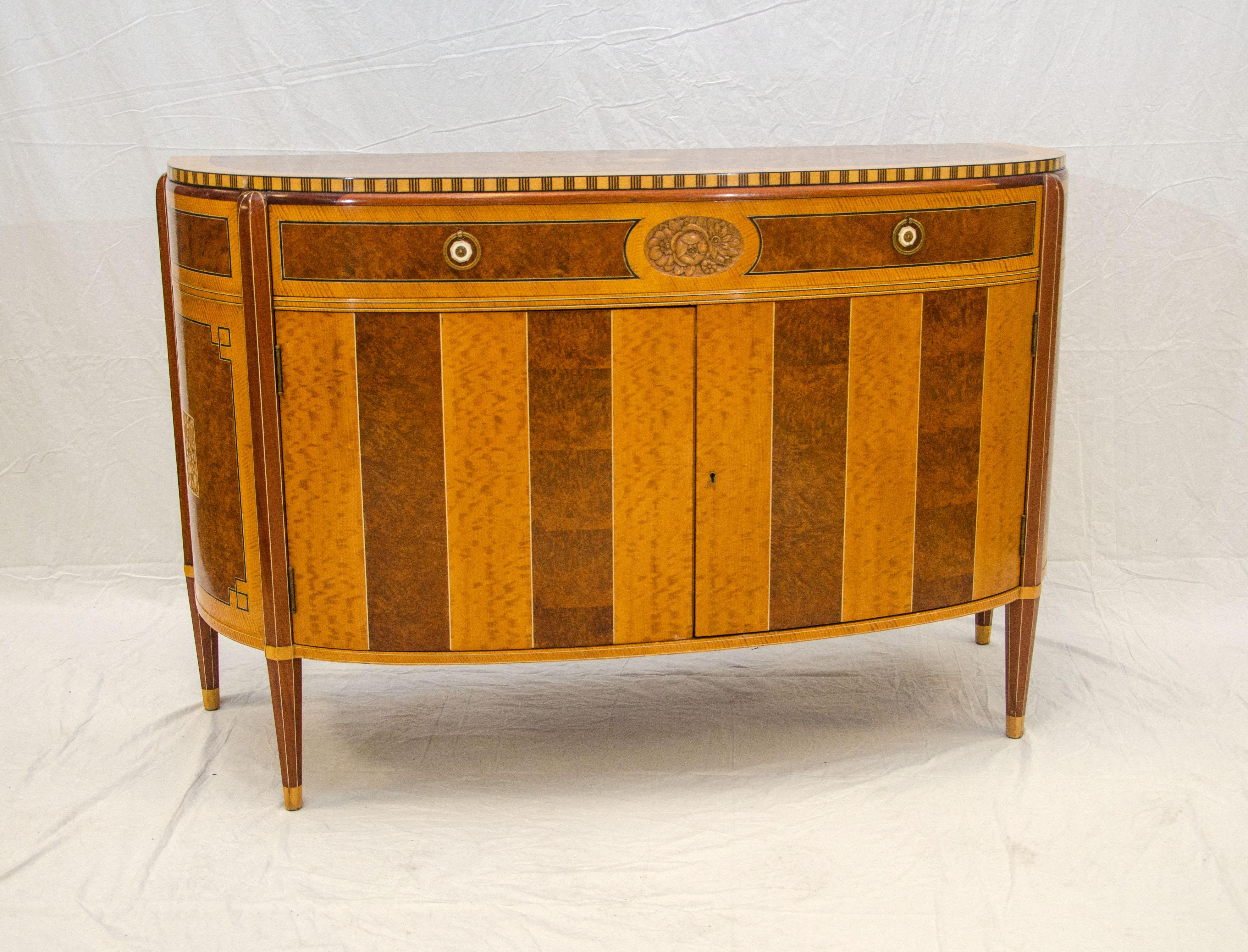 This beautiful dresser was well designed and constructed in a curved demi-lune shape with a French influence, burl walnut, tiger maple, and curly maple accented by ebony and maple stringing inlays throughout, also accented by an Art Deco floral