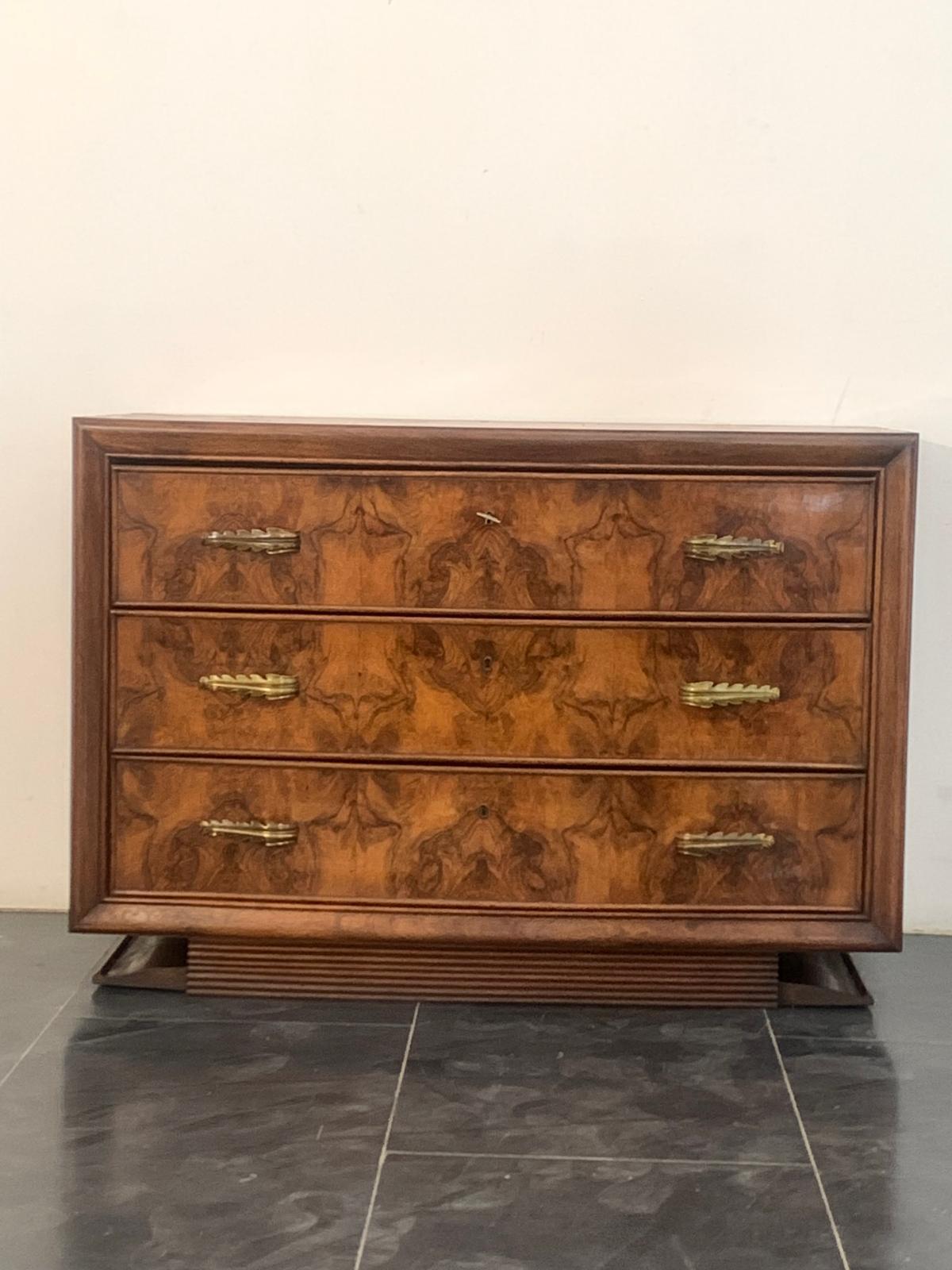 Cassettiera Premuda di Mobili di Lissone

Questo design offre un'interpretazione esemplare dello stile Art Deco.
La base grissinata sostiene un corpo delicatamente curvo in radica di noce. Il frontale presenta cornici in legno massiccio che