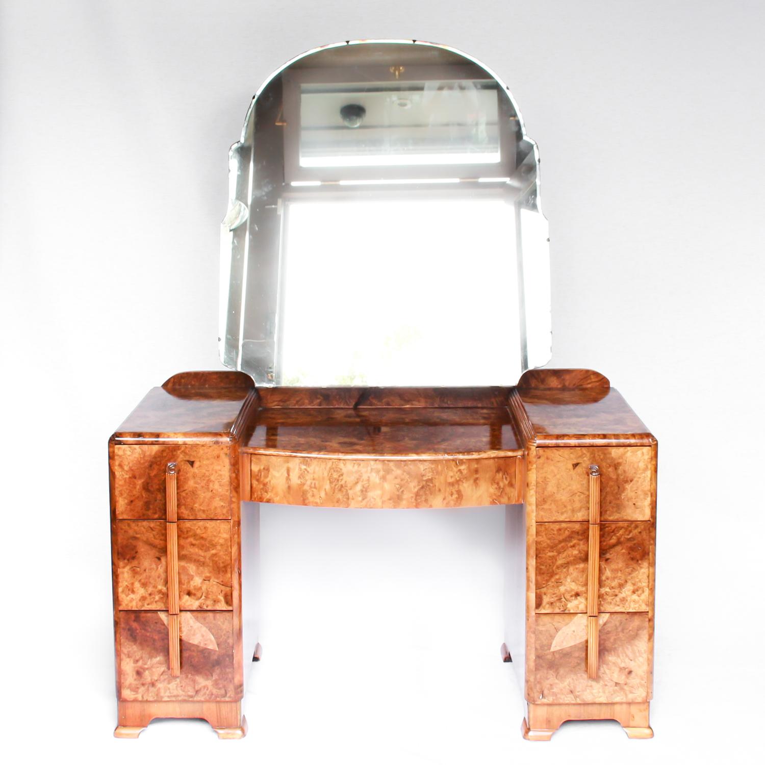 An Art Deco dressing table with drawers to centre and both sides. Shaped, arched, original mirror. Burr walnut throughout. 

Origin: English

Date: circa 1930.
 
