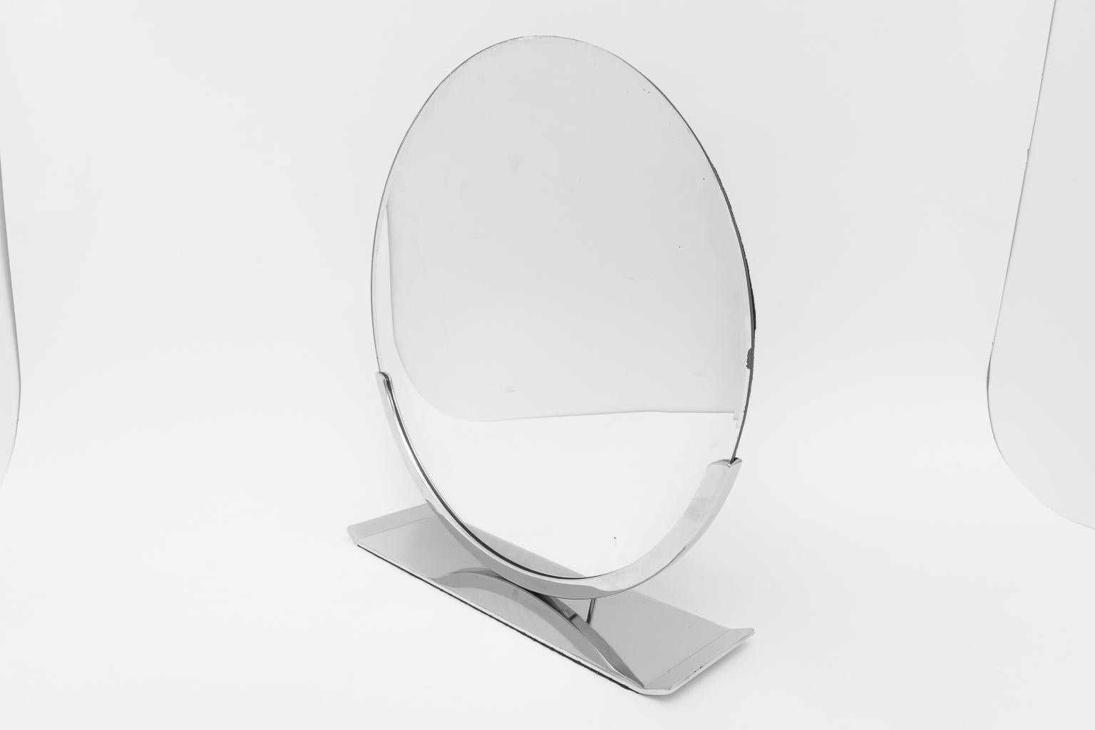 This stylish American Art Deco vanity table mirror was designed by Norman Bel Geddes for the Simmons Furniture Company.  The piece is nickel-plated and retains its original mirror and has a black felt lining on the backside and bottom of the