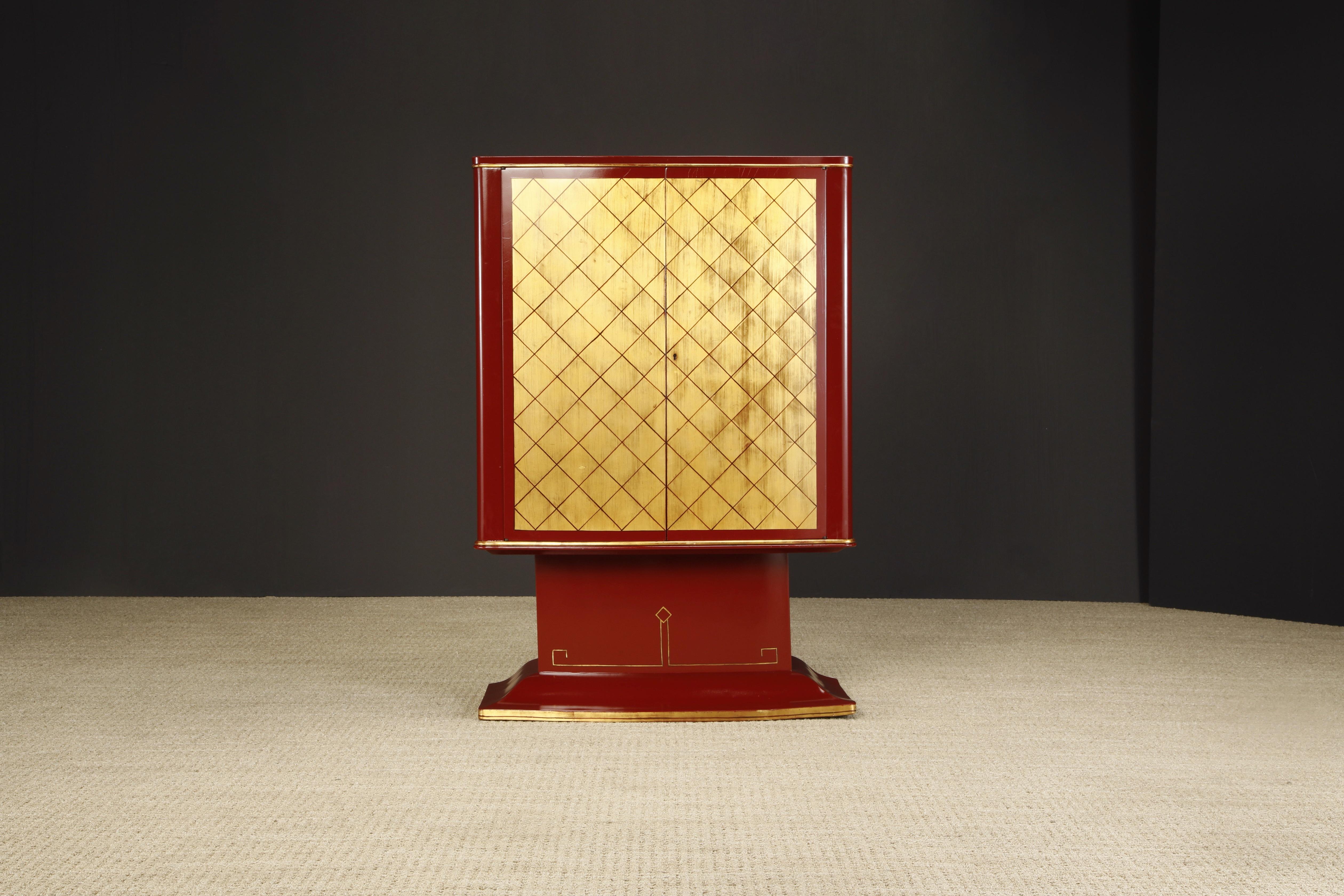 This restored art deco cabinet features gold leaf double doors, trim and base detailing with lacquered burgundy exterior. Ideal for use as a dry bar for holding liquor and glassware or as an apothecary cabinet. 

Beautiful lacquered burgundy with