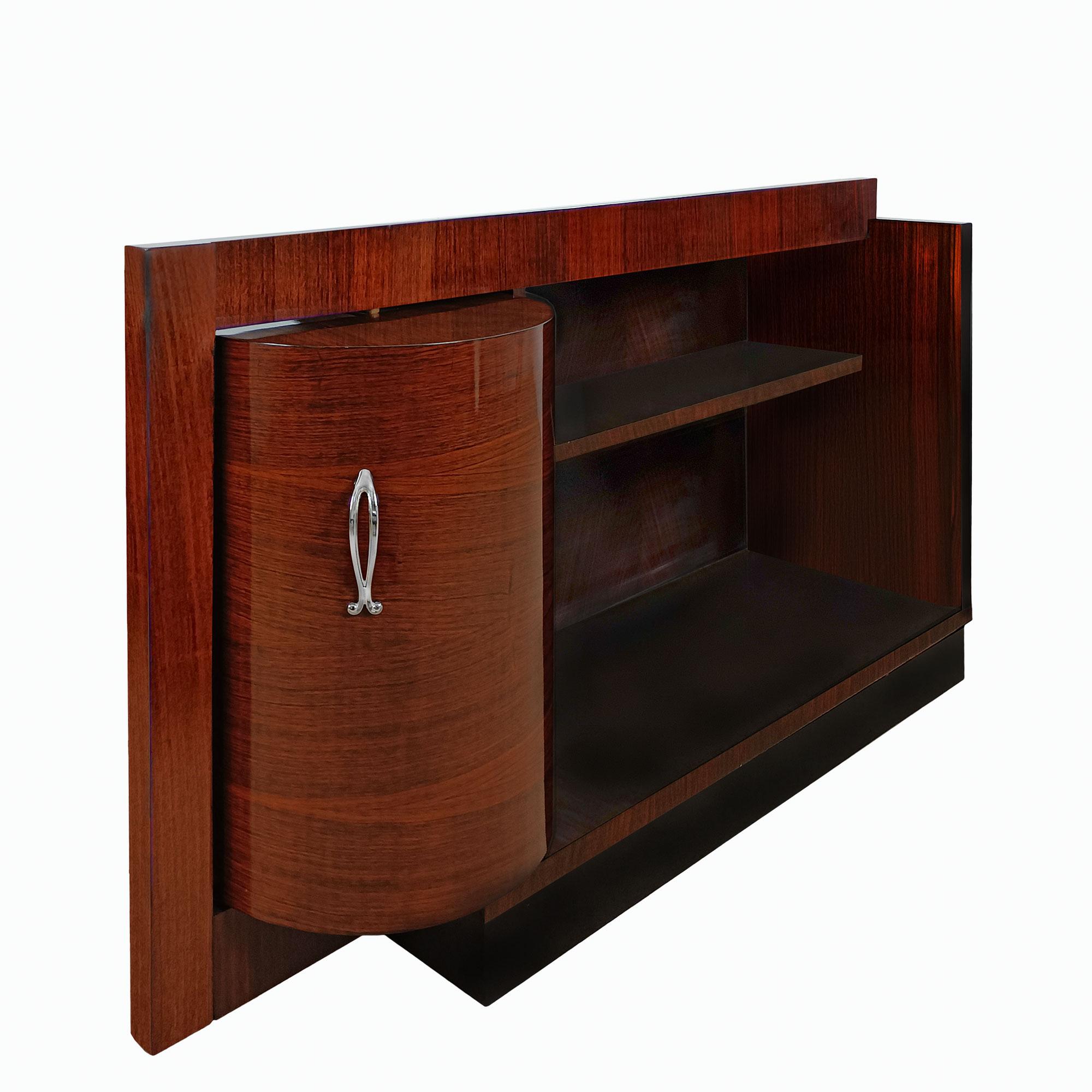 Art Deco dry bar or side cabinet in solid wood with rosewood veneer and black lacquered base. The tambour door opens onto a lemon veneered compartment for bottles and glasses, the oak hooks and their trays rotate around a central axis. Veneered and