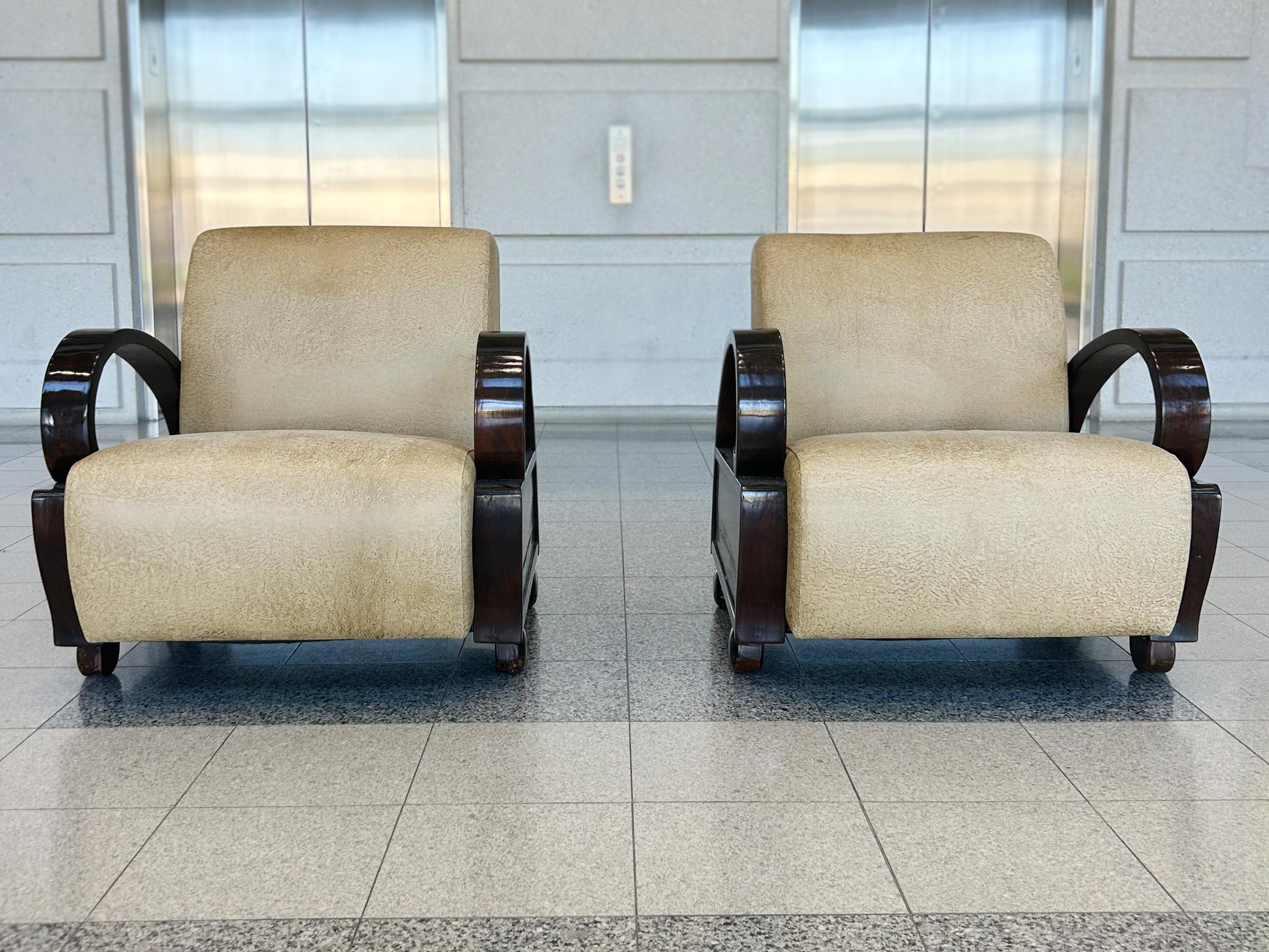Forme tonde e bulbose e curve spettacolari caratterizzano il design di queste sedie da club in stile Art Déco, composte da strutture in legno d'ebano e cuscini rivestiti in pelle. La cosa più sorprendente sono i braccioli in legno curvato che si
