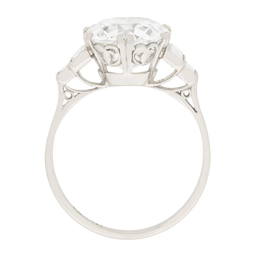 Stepped shoulders set with diamond baguettes lead to a dramatic EDR certified, 3.67 carat, transitional cut diamond at the centre of this original Art Deco engagement ring

In quintessential 1920s fashion, double claws secure the principal stone