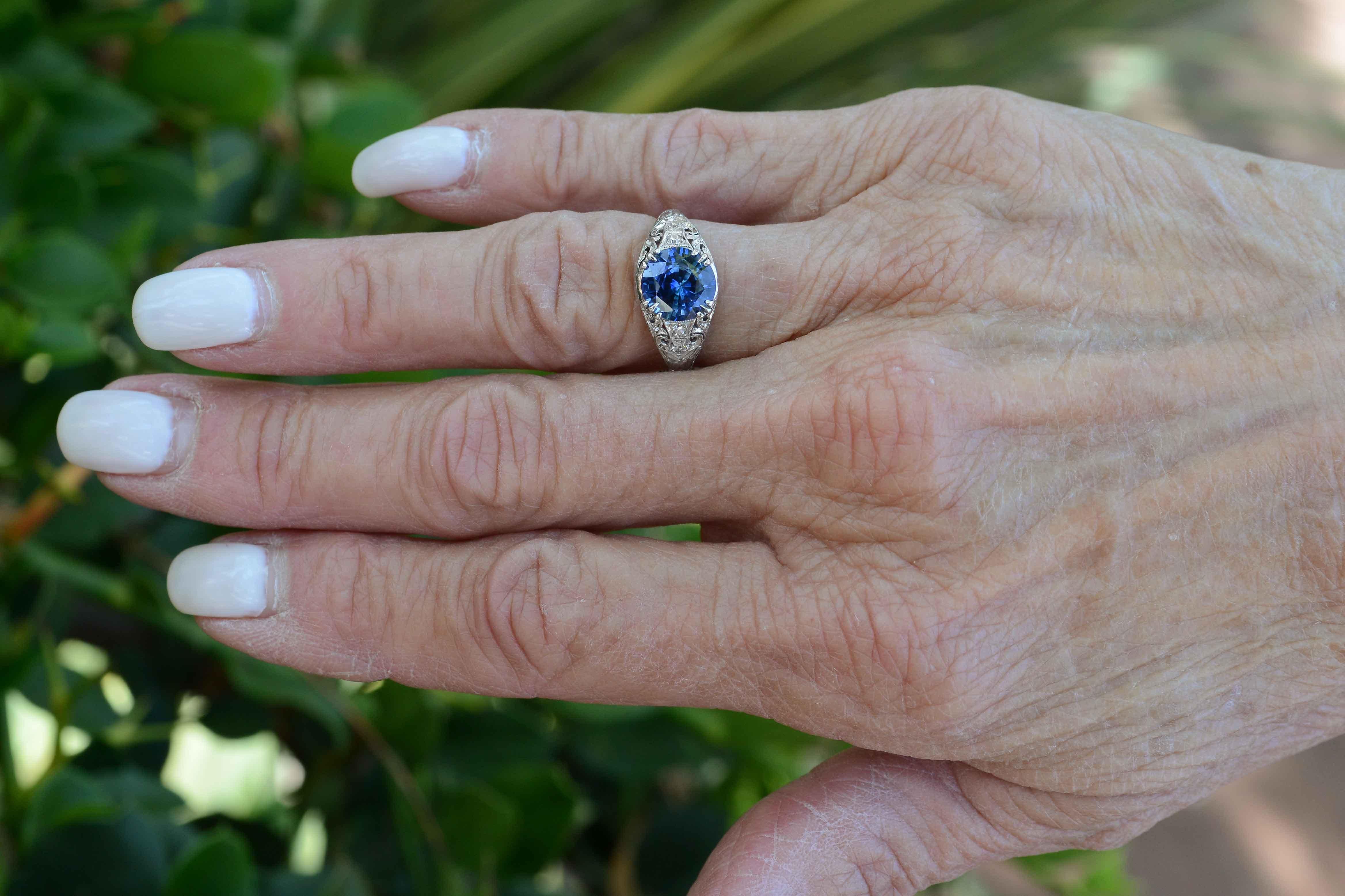 The vivid, intense royal blue color of this 2.64 carat gemstone only tells part of the story. An enchanting Art Deco Edwardian era heirloom circa 1915, the platinum setting draped in filigree, hand engraving and milgrain makes for a highly coveted