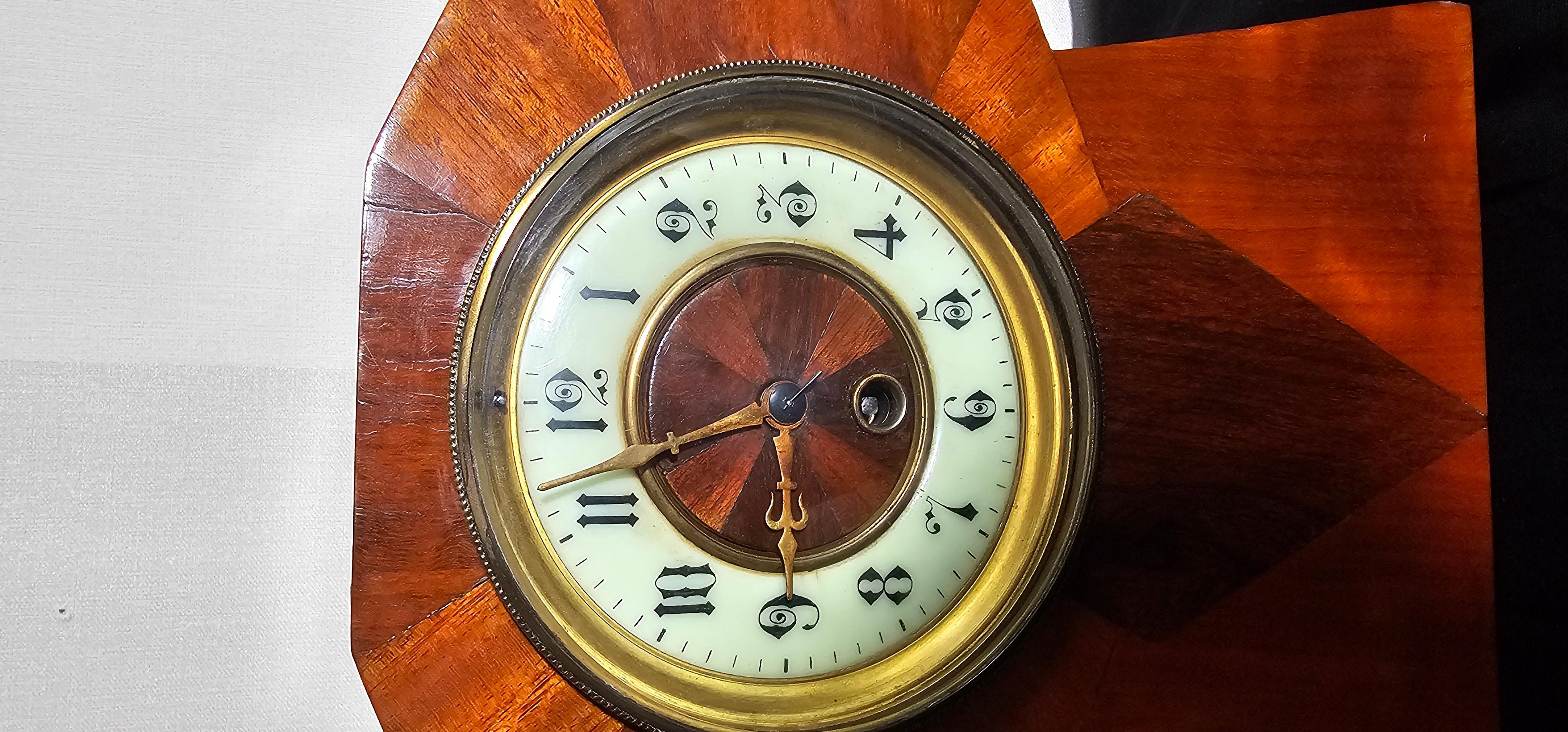 Esta es una  ejemplo muy interesante de un eduardiano de principios de 1930  / Reloj de chimenea Art Decó en perfecto estado de funcionamiento. La carcasa está tallada en madera de teca y bien barnizada . Diseño de revestimiento muy Art Déco en teca