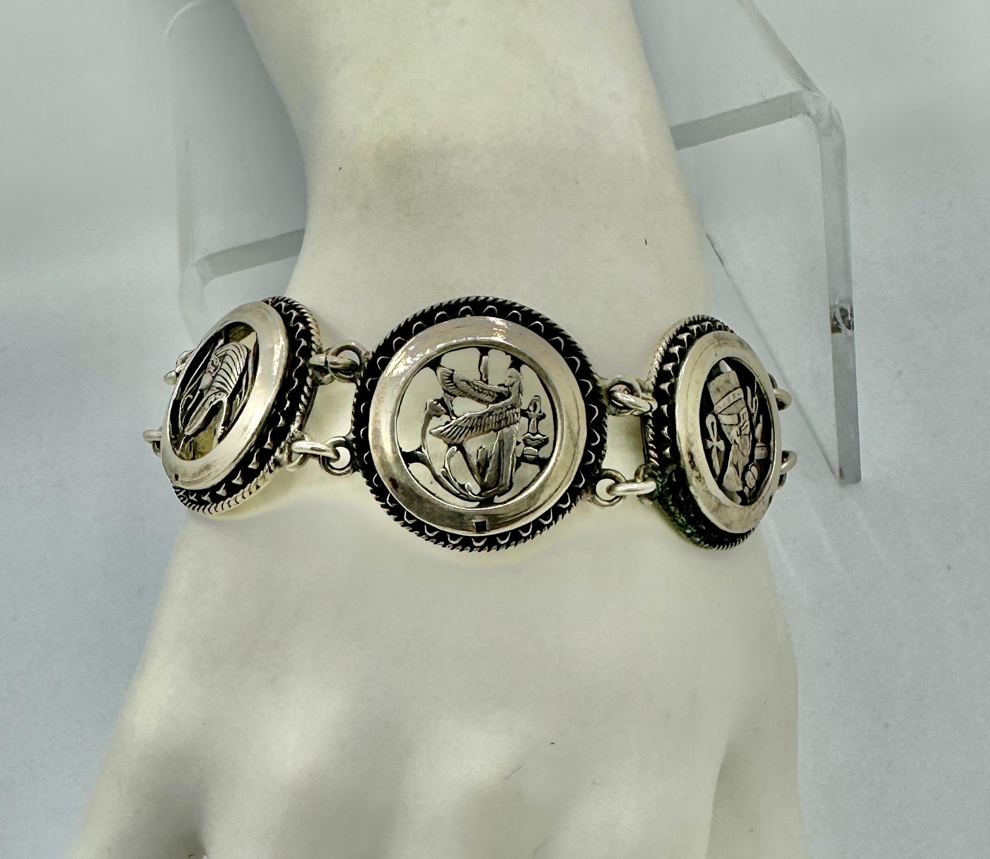 Dies ist eine wunderbare antike Art Deco Egyptian Revival Armband mit spektakulären Bildern aus dem alten Ägypten in Sterling Silber.  Die Bilder zeigen einen Streitwagen, König Tut, einen geflügelten Pharao, Nofretete und Lotusblumen. Das Armband