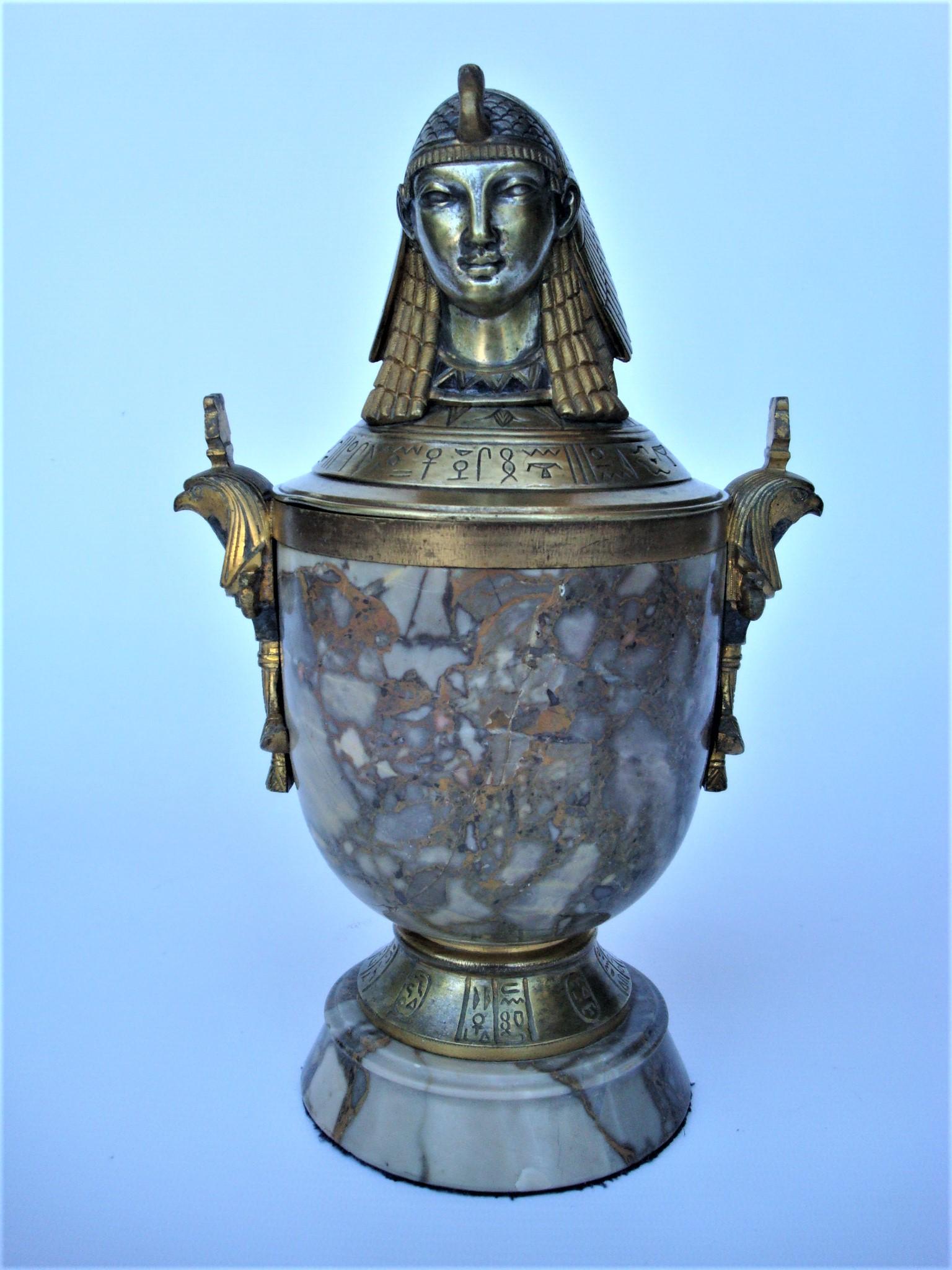 Art Deco Egyptian Revival bronze & marble urn with lid
Egyptian revival lidded bronze and marble urn. Features the bust of a sphinx at the top of the lid.
Marble urn with bronze Egyptian woman accents.