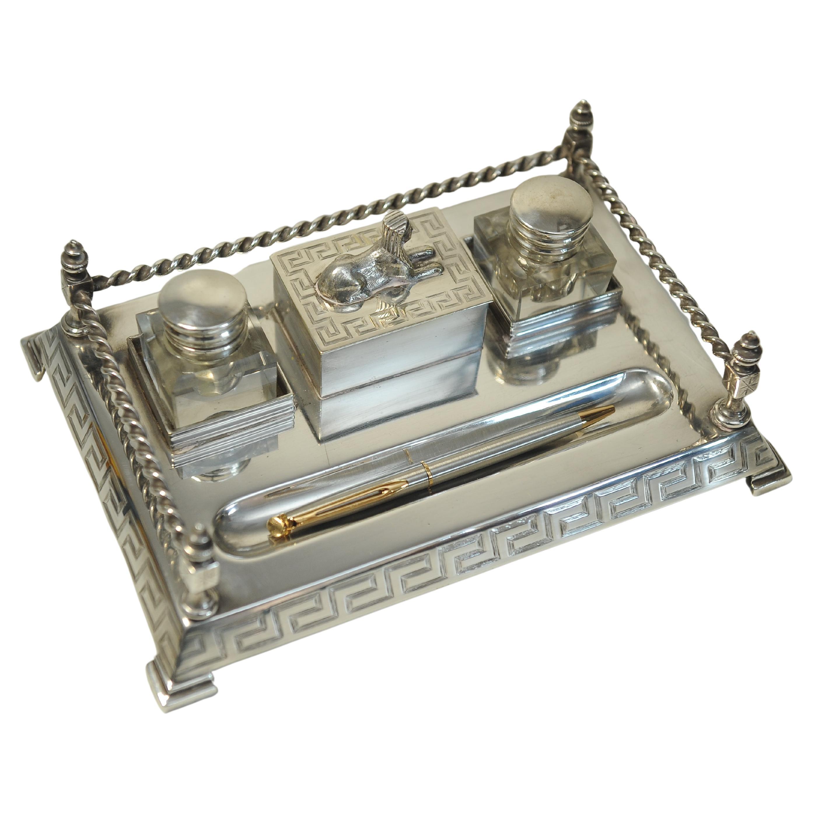 An Impressive Art Deco Egyptian Revival Desk Stand
With Two Cut Glass Metal Topped Inkwells With A Formed Pen Tray
Base Decorated With A Rope & Key Design

Will Be Supplied With Two Cut Glass Inkwells A Modern Day Quill Pen, Notepad & A Vintage