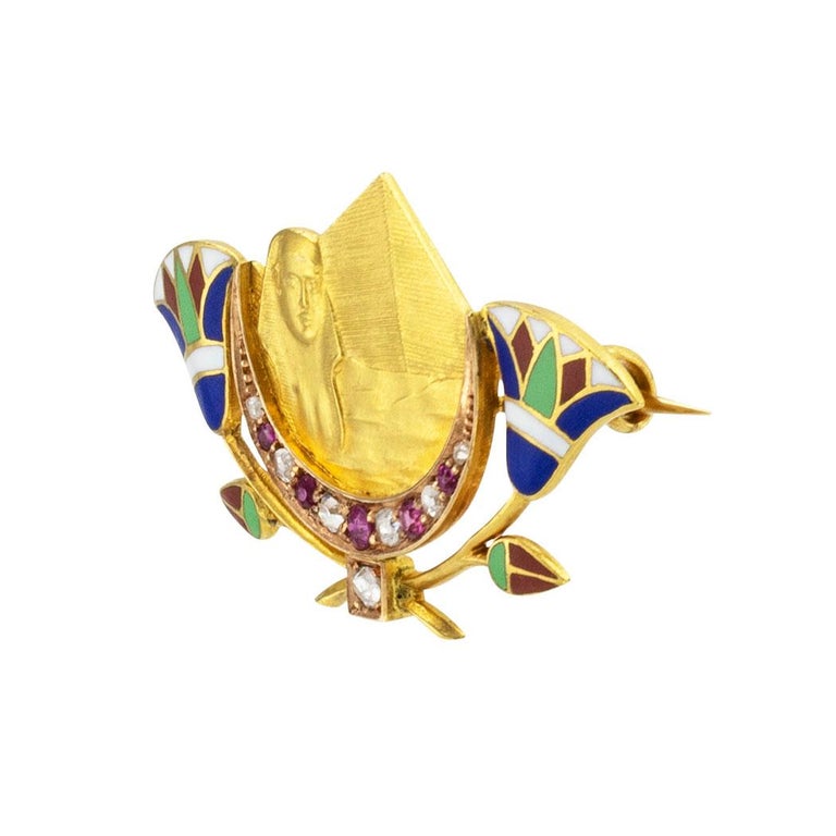 Art Deco Egyptian Revival enamel diamonds rubies and yellow gold brooch circa 1925. *

ABOUT THIS ITEM:  #P-KJ68E. Scroll down for specifications.  Centering upon a gold cameo depicting The Great Sphinx, The Great Pyramid, and the waters of the