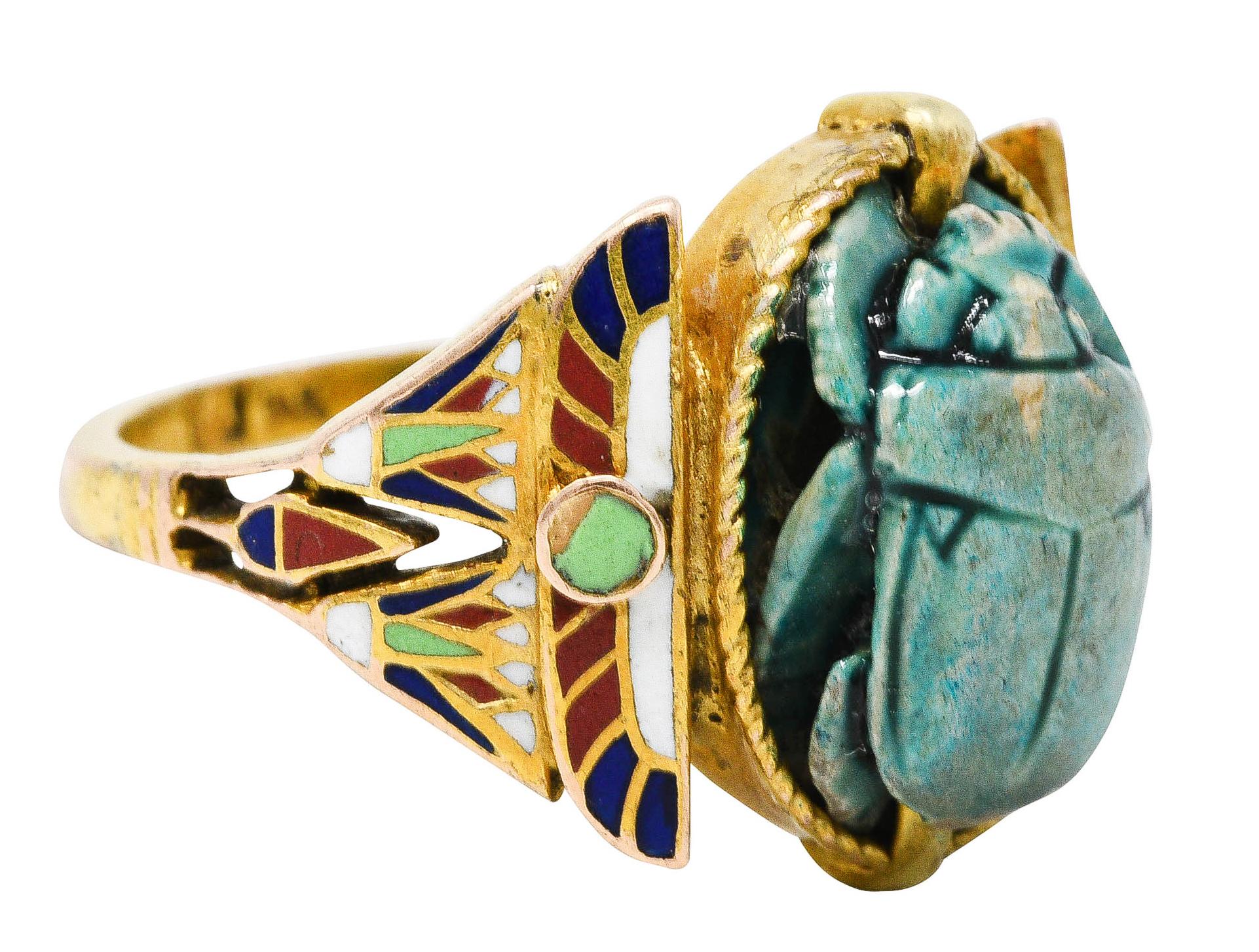 Centering hardstone deeply carved to depict a scarab and hieroglyphics - coated in turquoise faience

Flanked by stylized and colorful shoulders - glossed in enamel that exhibits some loss consistent with age

With a winged scarab motif and lotus