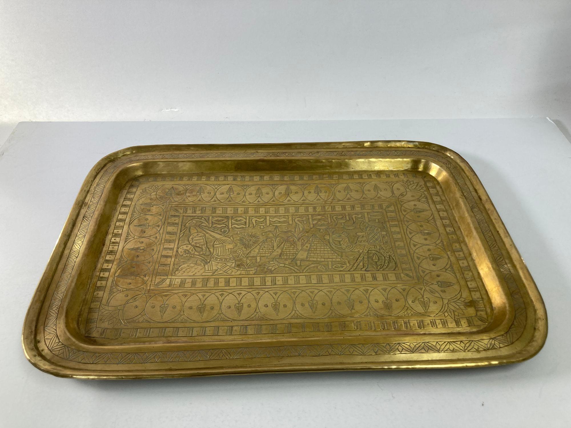 Antique 1920s Art Deco Egyptian-Revival rectangular brass tray.
This stylish hand-made brass tray platter dates from the early 1920s with its motif of Art Deco stylized Egyptian figures, sphynx, camel, pyramids, snakes and hieroglyphics.
Middle