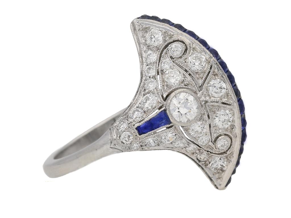 Anello Art Deco Egyptian Revival con zaffiri e diamanti. Incastonato con una linea verticale di diciassette zaffiri quadrati naturali taglio francese non valorizzati, inoltre quattro zaffiri quadrati naturali taglio francese non valorizzati sulle