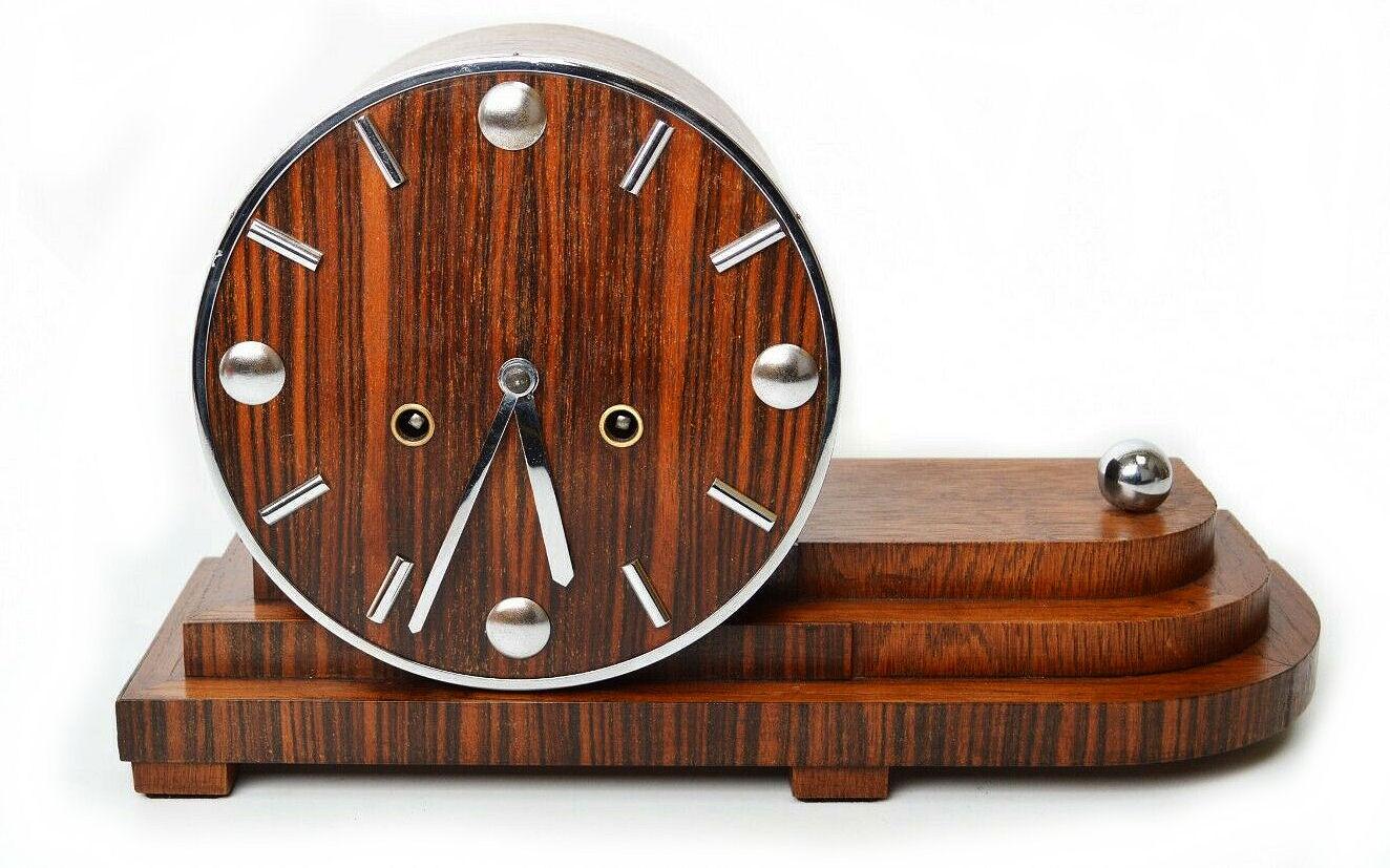 Absolutely spectacular wooden Bauhaus Art Deco mantel clock manufactured by Pfeilkreuz Junghans Germany in the 1930's . The case has a superb cascaded architectural design with pronounced chrome features. The dial is cleverly mounted to the base and