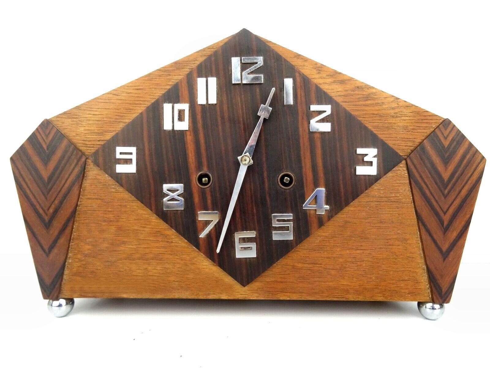 Absolutely spectacular oak & calamander Art Deco mantel clock manufactured by Pfeilkreuz Junghans clock company In Germany in the 1930's . The case has a angular design with raised chrome numerals and dial hands. The veneer is a stunning striped