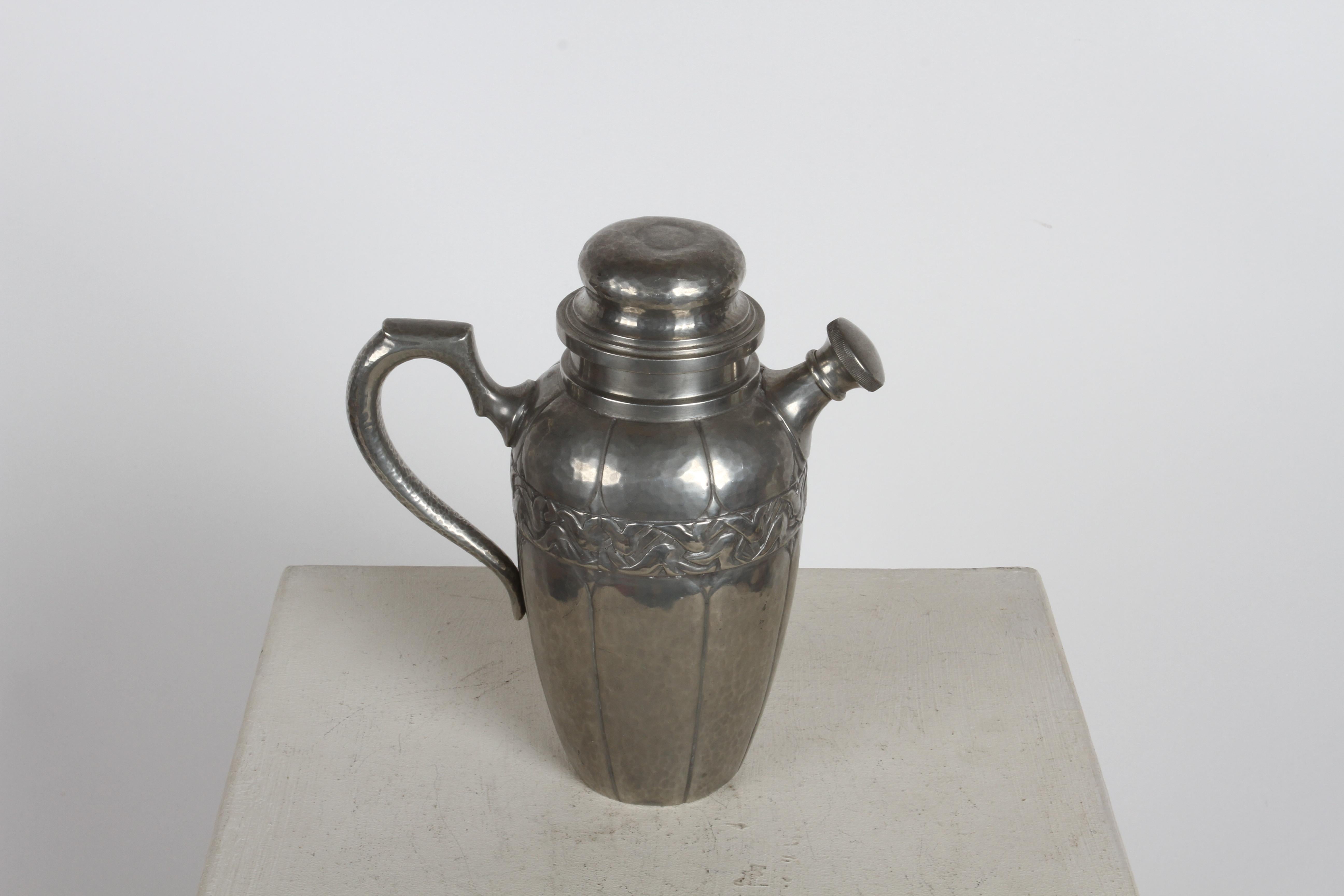 Rare 1920s Art Deco period cocktail shaker by Einar Dragsted (1887-1967) Danish Silversmiths in pewter with handle, spout and removable top. This hand wrought and hand hammered shakers has a warm patina to its pewter, with incised vertical lines,