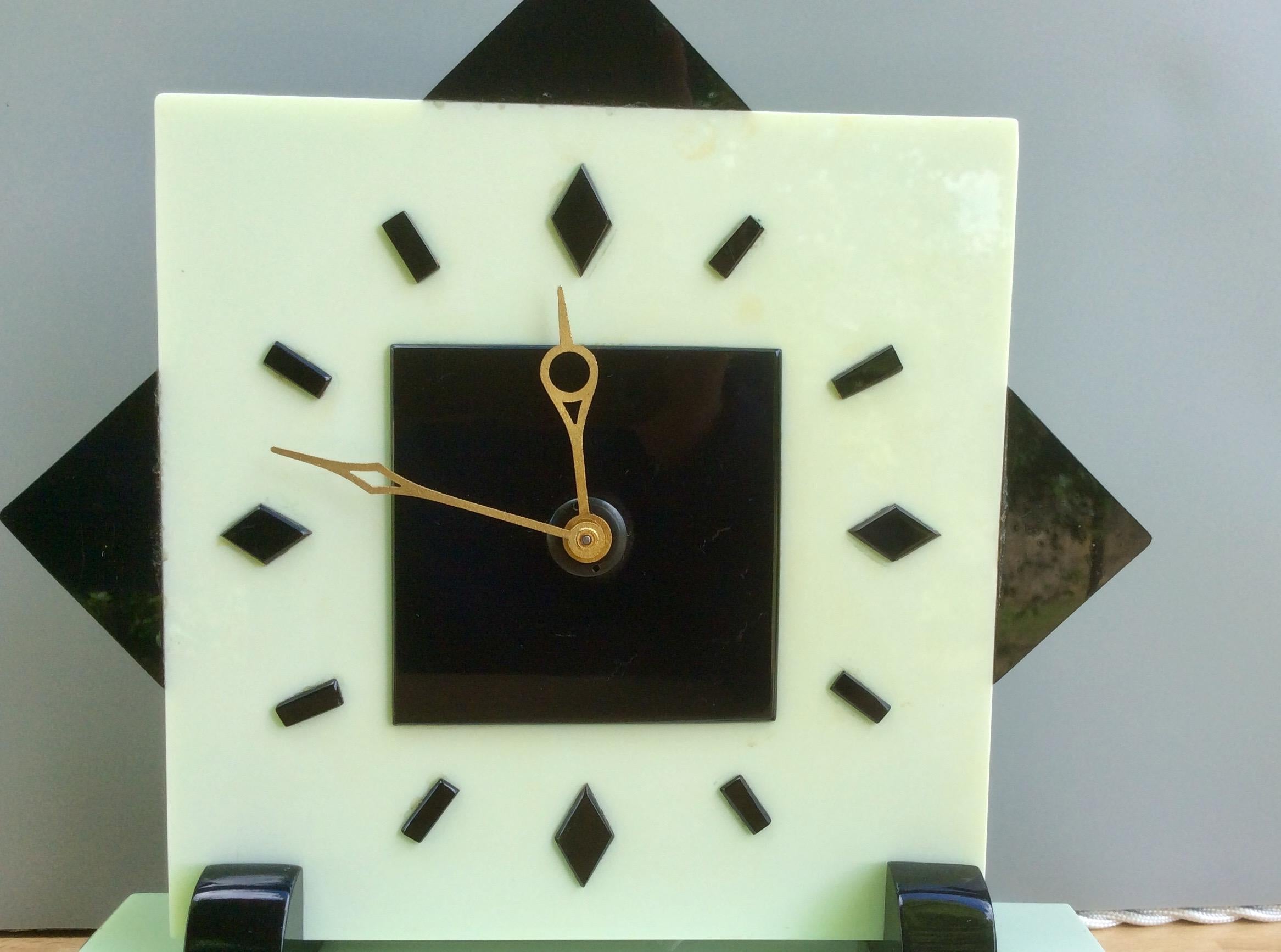 Art Deco timepiece

Art Deco electric timepiece in a light green and black Bakelite case standing on rectangular shaped feet and resting on a stepped two color plinth.

Square dial with baton markers and gilded hands.

Electric movement by