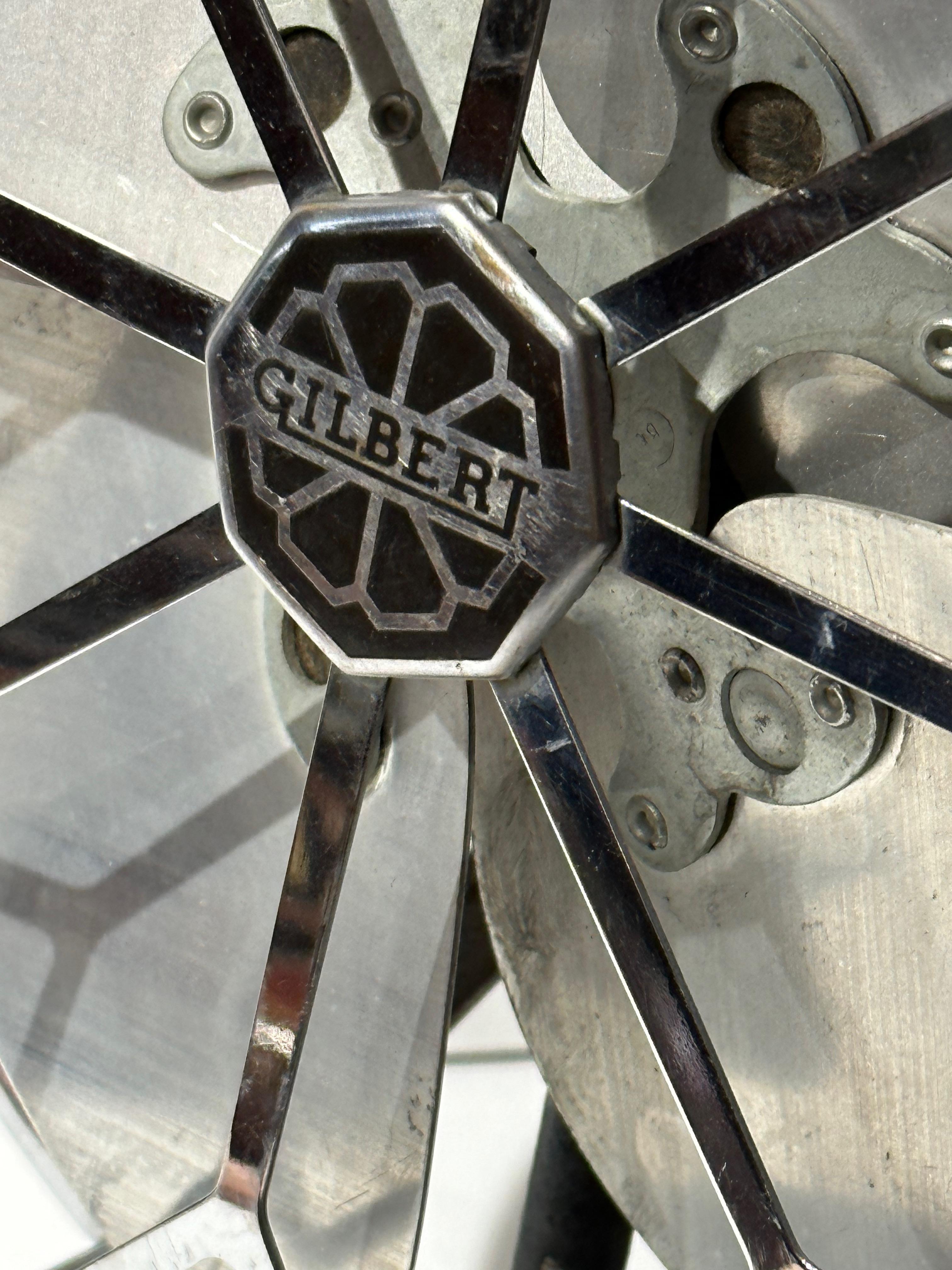 A 1930s Gilbert brand electric fan – this is the “Aristocrat” model with its floral shaped cage that echoes the floral shaped logo medallion in the center. It has Aluminum blades, a black base, and an unusual plug with two “finger holes” for an easy