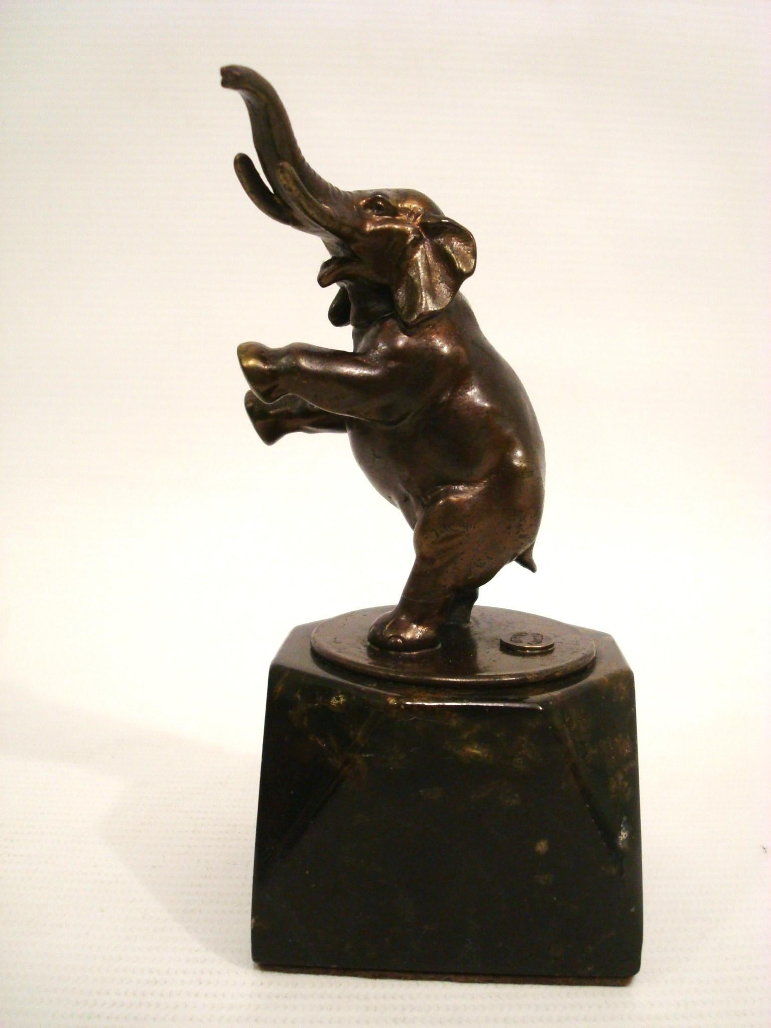 Art Deco Pewter Elephant Paperweight. Retailed by Asprey - London 1930´s
Small statue of an elephant standing on its hind legs with its trunk raised. The statue is mounted on a dark, marble base. The elephant's front legs are lifted, and the trunk