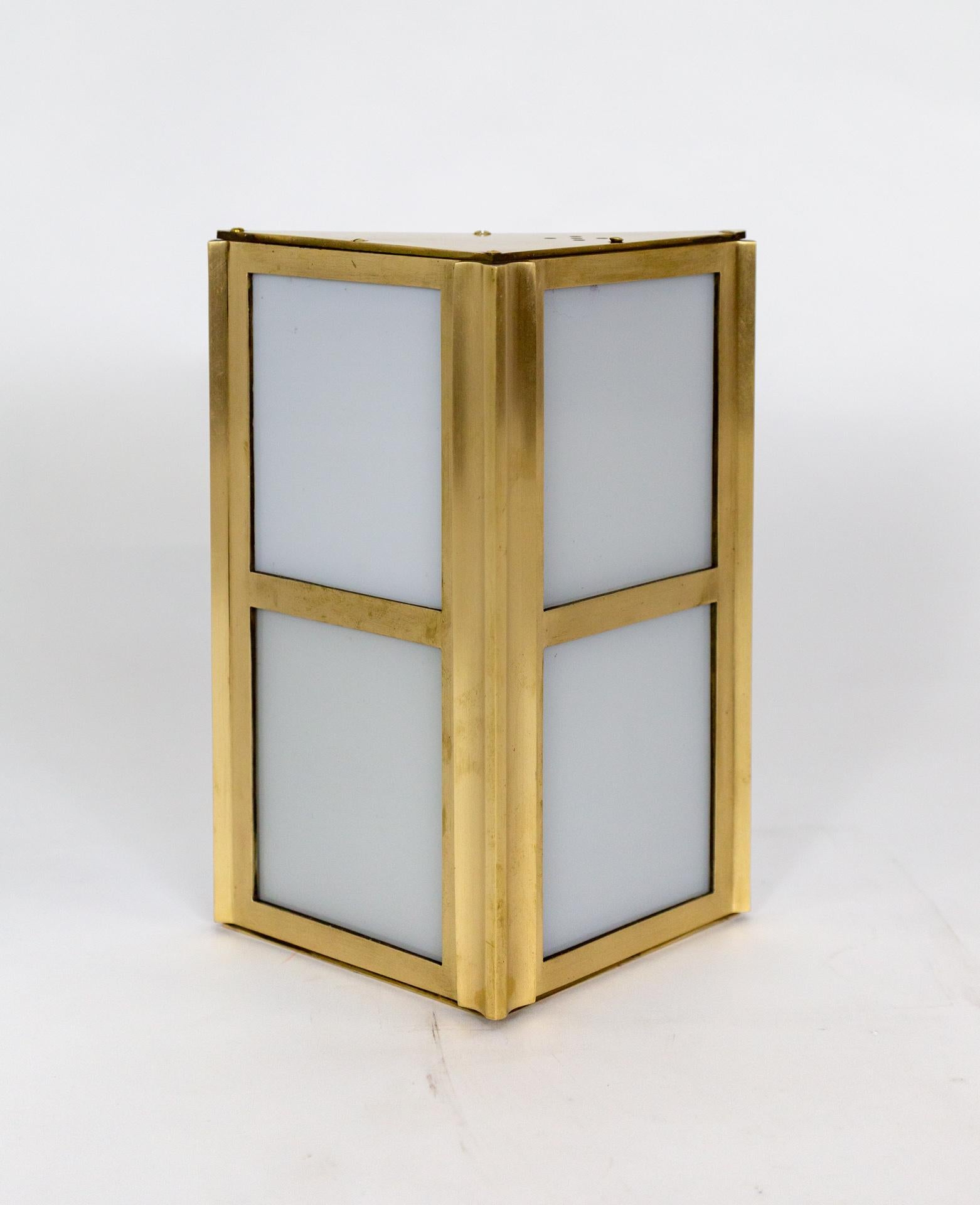 These finely crafted sconces are refashioned from elevator lights from the 1930s.  The heavy, solid brass frame has two rectangular faces divided into 4 windows with original white glass.   Creates an even, diffused light.  Each sconce has two