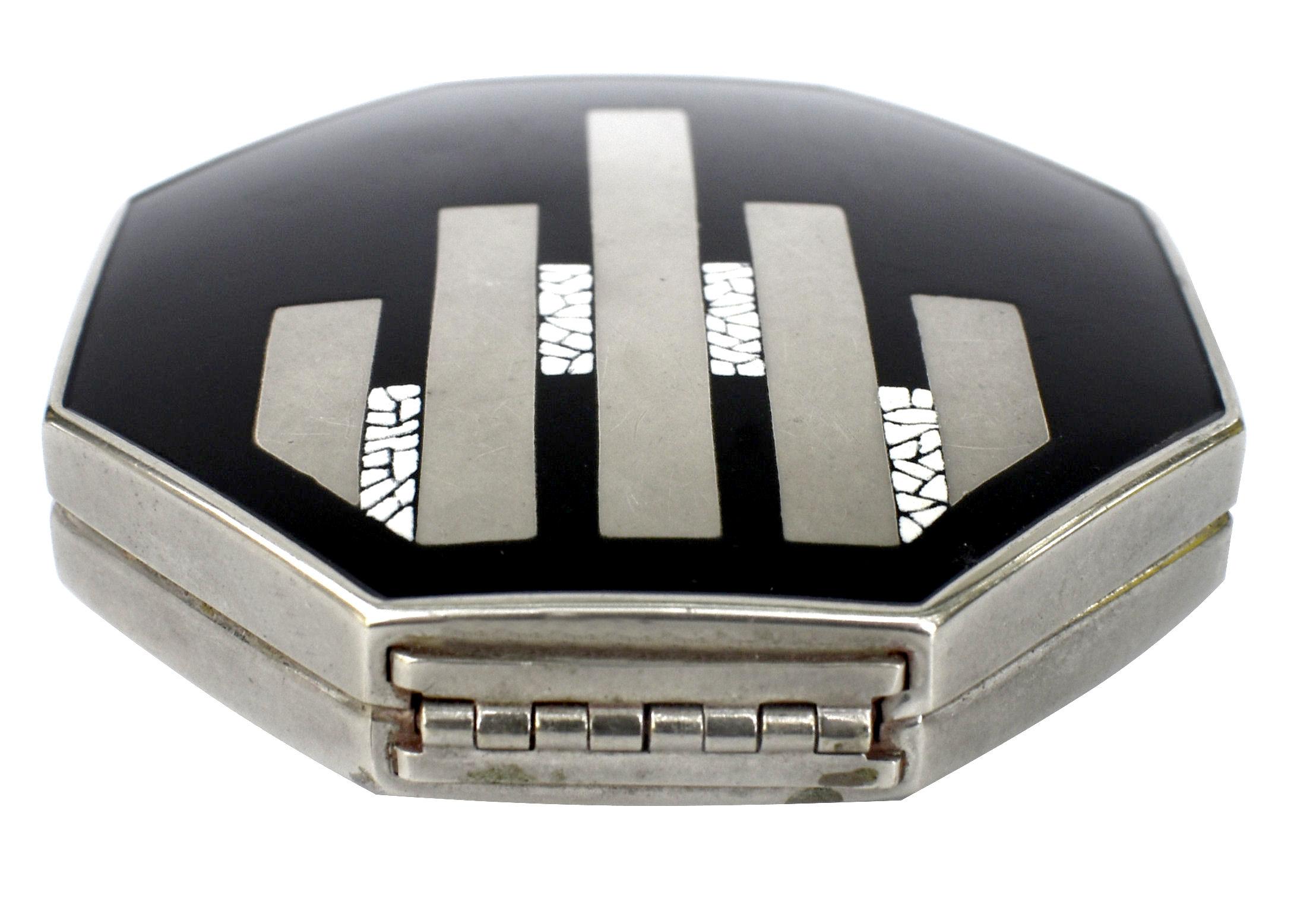 Original Art Deco Black and chrome enameled ladies powder compact. Produced by Elizabeth Arden sometime in the late 1920's - 1930's. Inside the compact it is marked Ardenette. The compact is hexagon in shape. The lid is black enamel with silver and