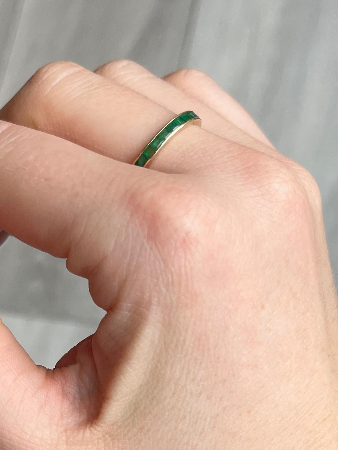 The emeralds set within this 14ct gold band are square cut and measure 5pts each. They are beautifully bright stones. emerald total approx 1.4ct.

Ring Size: M or 6 1/4 
Band Width: 2.5mm 

Weight: 1.3g