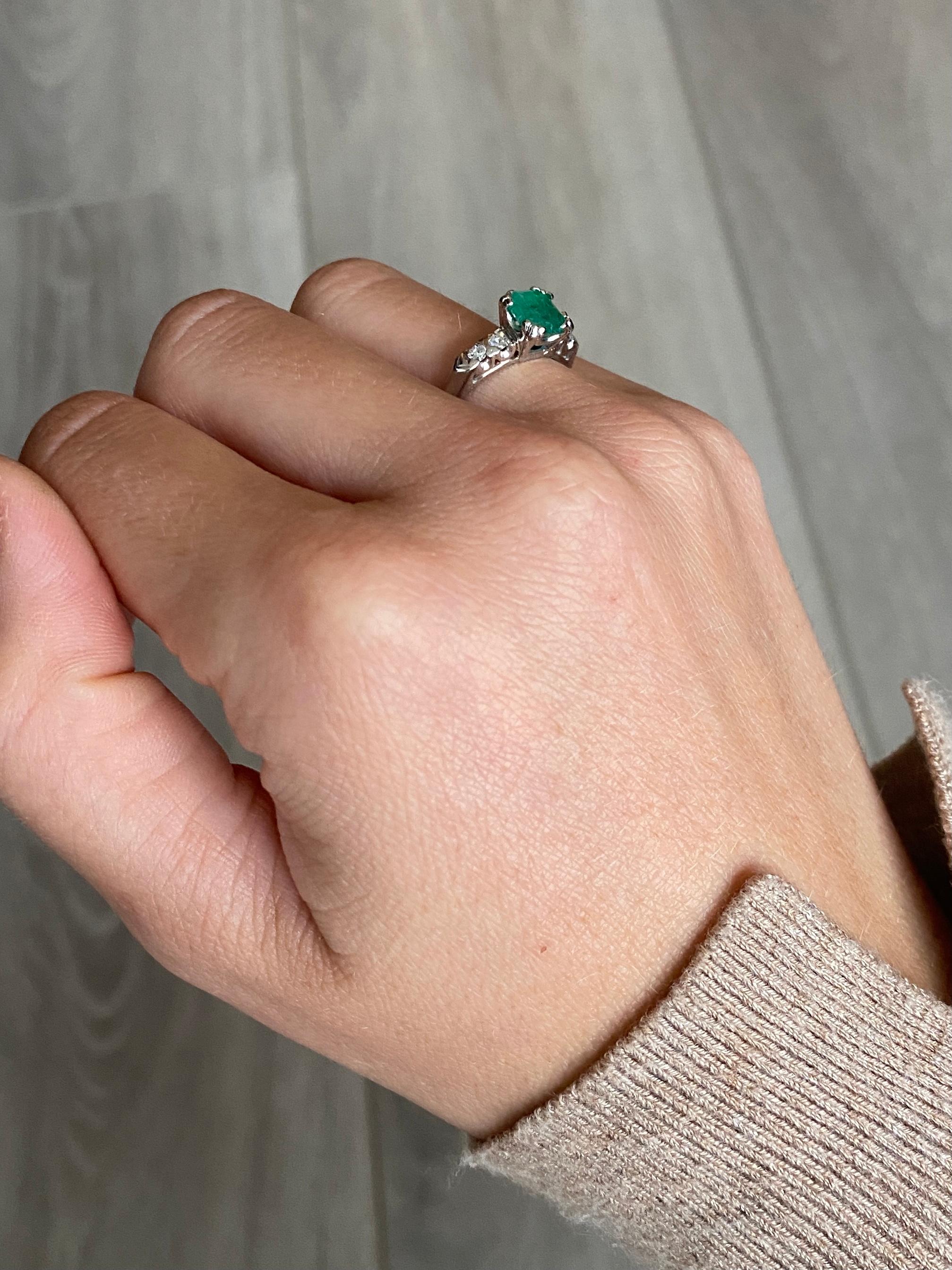 L'émeraude de cette bague mesure 1 ct et est d'une belle couleur. De chaque côté se trouve une paire de diamants totalisant 10pts par épaule. La bague est réalisée en or blanc 14 carats.  

Taille de l'anneau : L ou 5 3/4
Hauteur hors doigt :