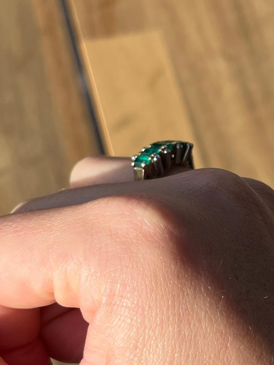 An exquisite five-stone ring set with beautiful emerald cut emeralds which total 70pts. Either side of this beautiful row of green stones are pairs of diamond points. modelled in 18carat gold. 

Ring Size: J or 4 3/4
Height Off Finger: