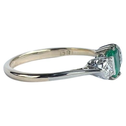 Lo smeraldo centrale è così luminoso e bello e misura 15pts. Ai suoi lati si trovano due brillanti diamanti taglio vecchio europeo di 10pt ciascuno. L'anello è realizzato in oro 18ct e le pietre sono incastonate in platino.

Misura dell'anello: M o
