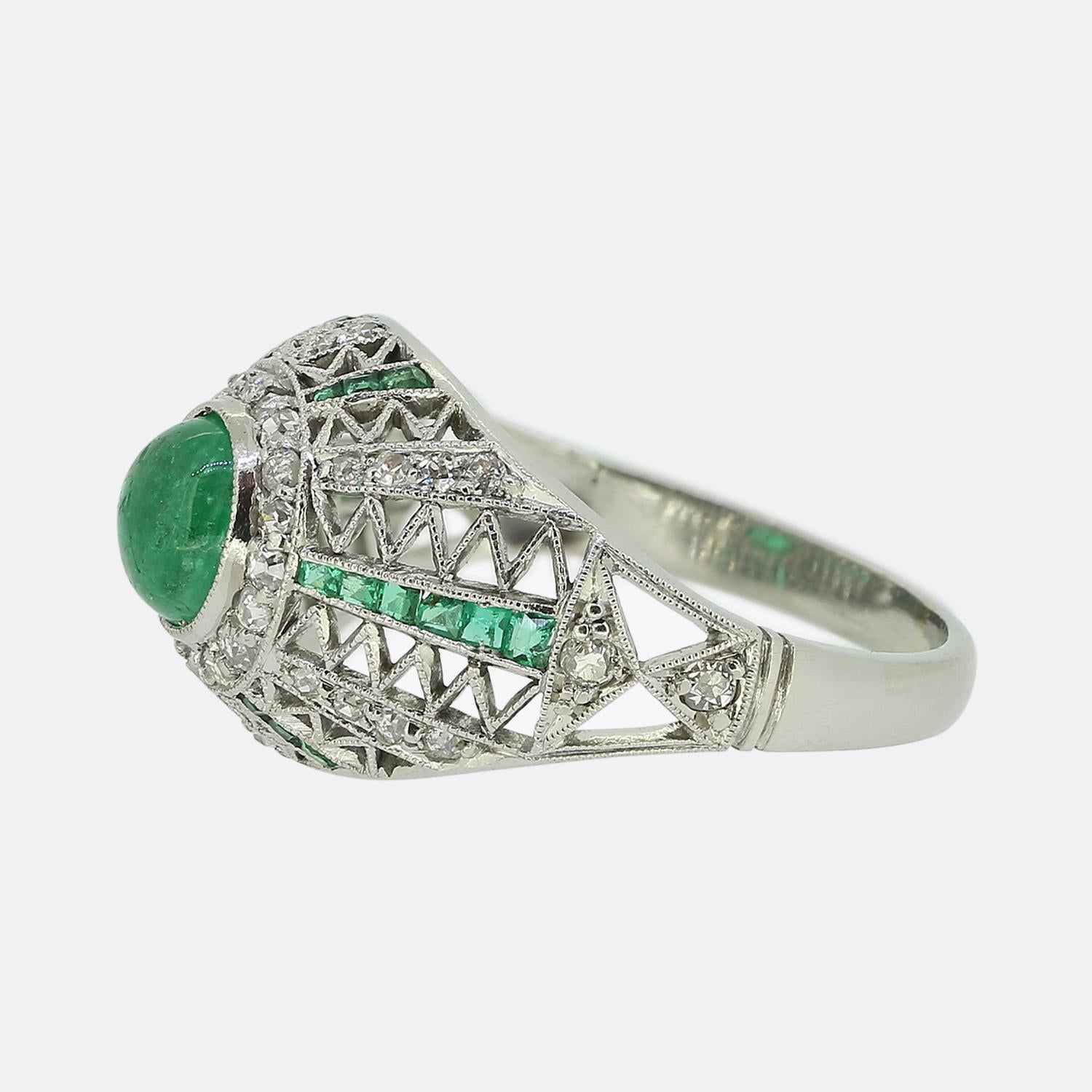 Here we have a fabulous emerald and diamond bombe ring crafted at a time when the Art Deco style was at the height of design. An open concave face has been crafted from platinum and showcases fine zig-zag filigree work. Detailed milgrain settings
